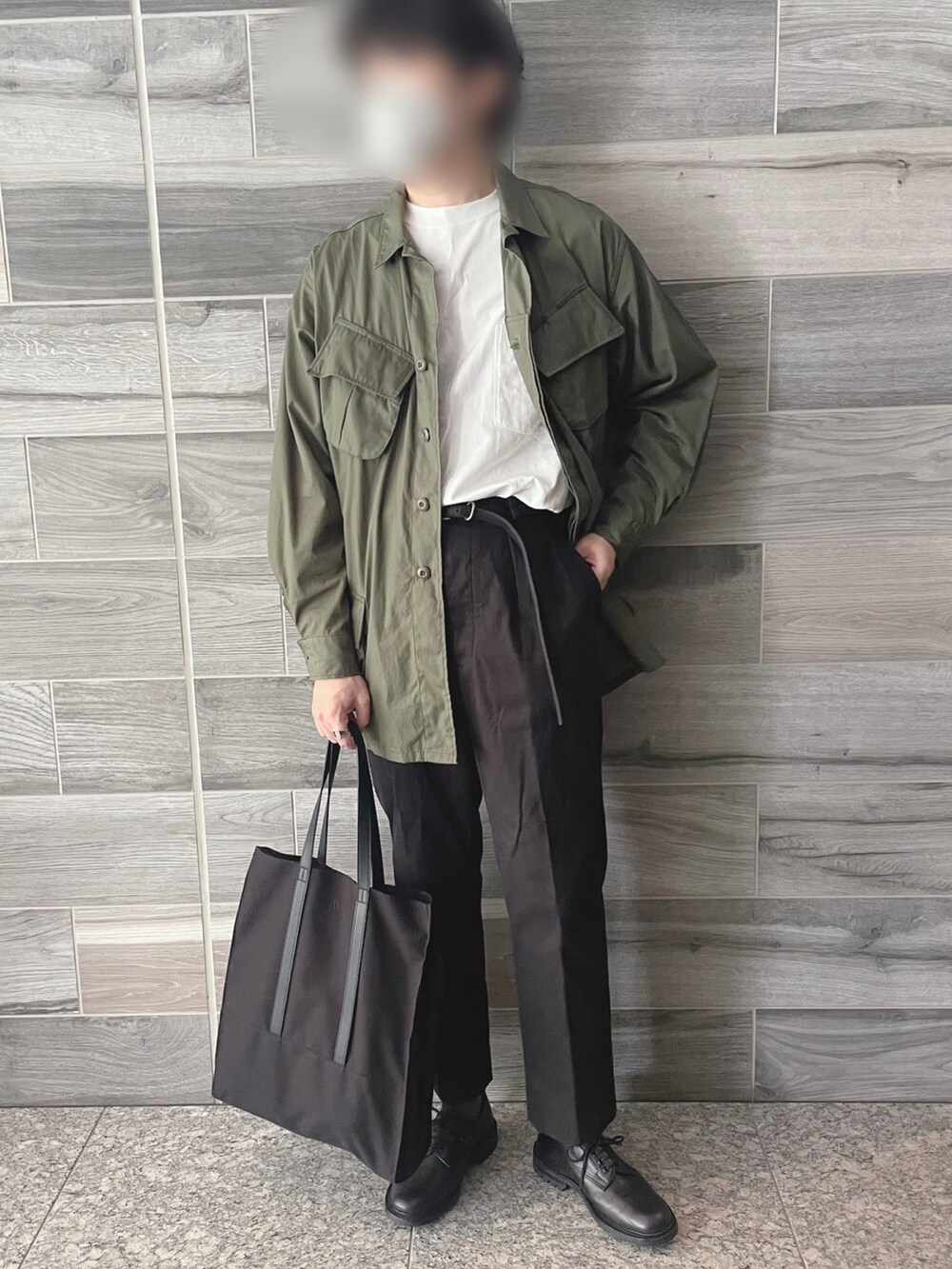 グリーン系のミリタリージャケット、ブラック系のスラックス、ブラック系のシューズを着用したメンズの秋コーディネートの4枚目の写真