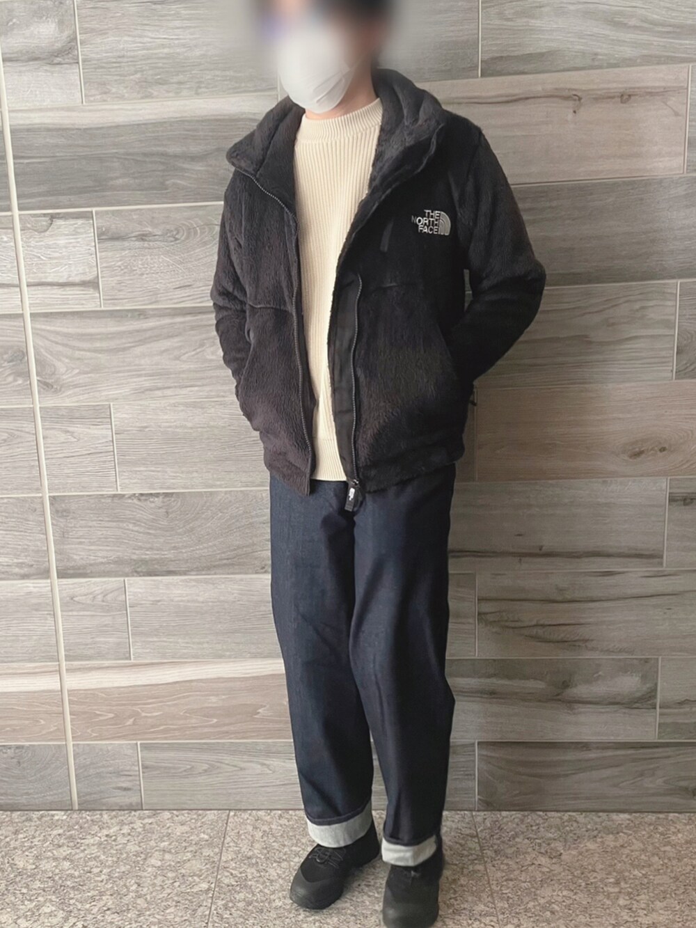 ブラック系のその他アウター、ホワイト系のニット/セーター、ブルー系のデニムパンツを着用したメンズの冬コーディネートの2枚目の写真