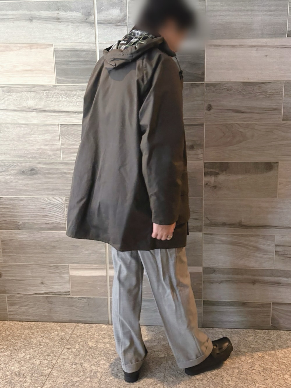グリーン系のジャケット/アウター、レッド系のニット/セーター、グレー系のスラックスを着用したメンズの冬コーディネートの2枚目の写真