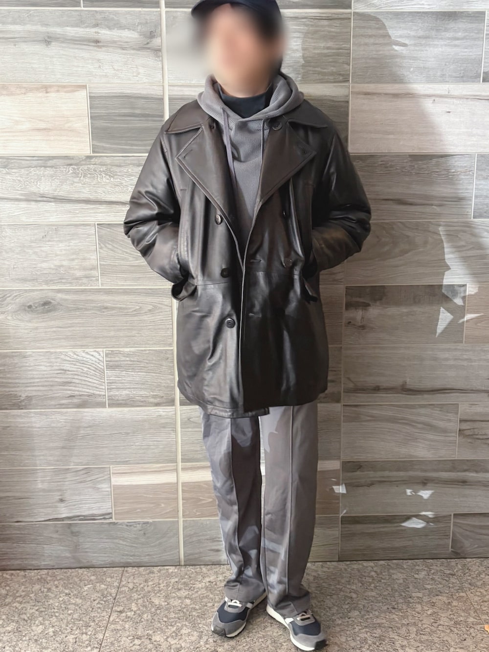 ブラック系のピーコート、グレー系のパーカー、ブルー系のTシャツ/カットソーを着用したメンズの冬コーディネートの2枚目の写真