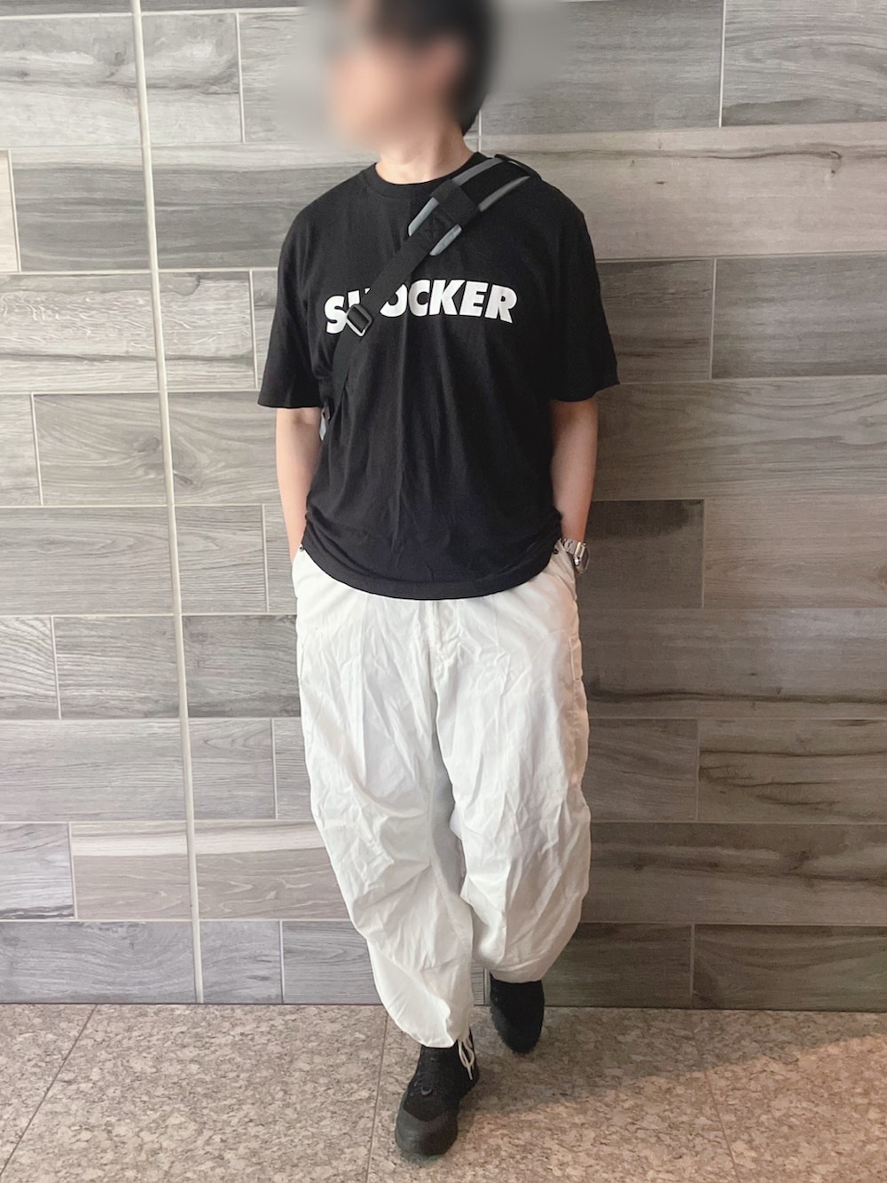 ブラック系のTシャツ/カットソー、ホワイト系のカーゴパンツ、ブラック系のブーツを着用したメンズの夏コーディネートの3枚目の写真