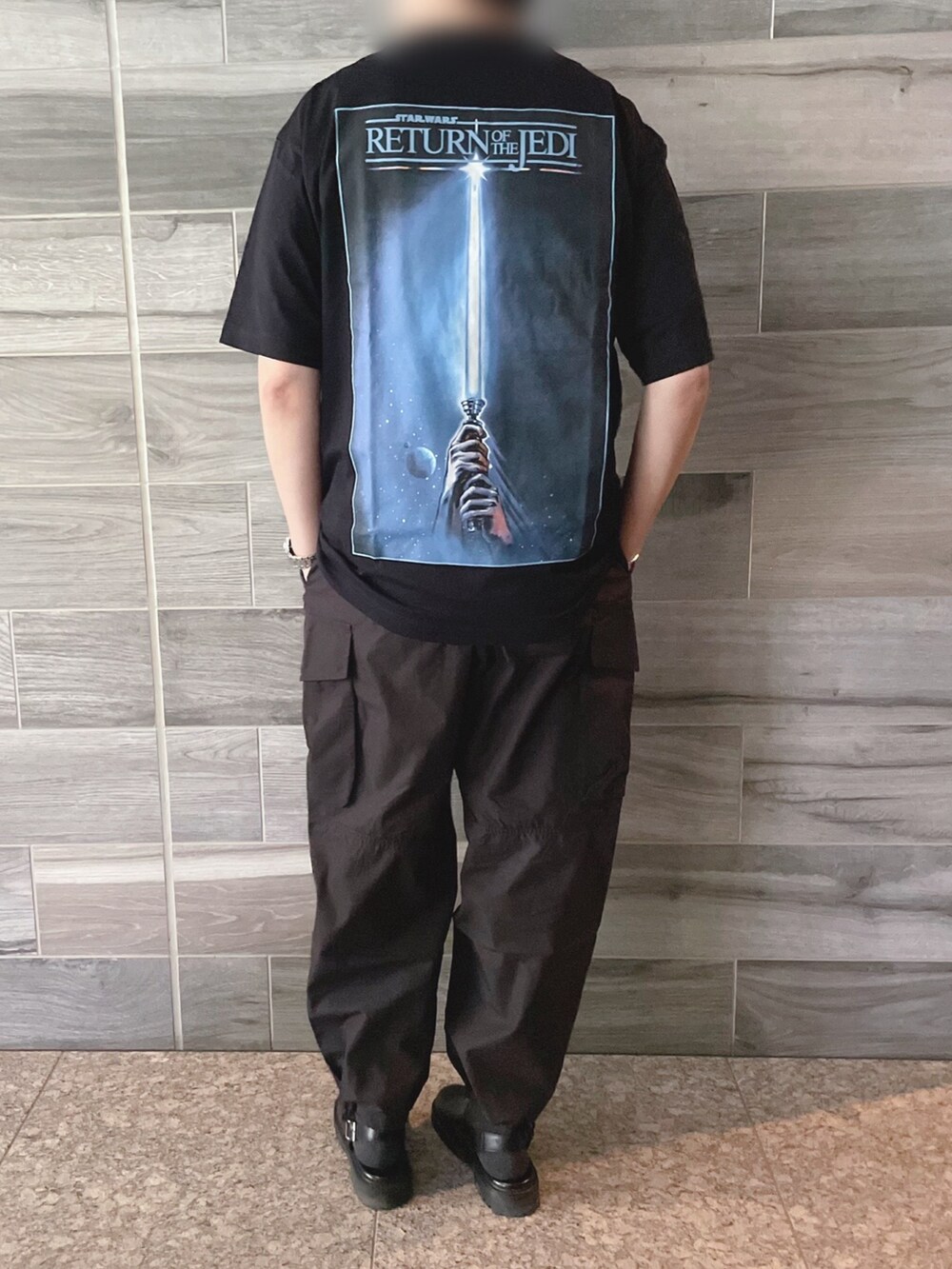 ブラック系のTシャツ/カットソー、ブラック系のカーゴパンツ、ブラック系のサンダルを着用したメンズの春コーディネートの2枚目の写真