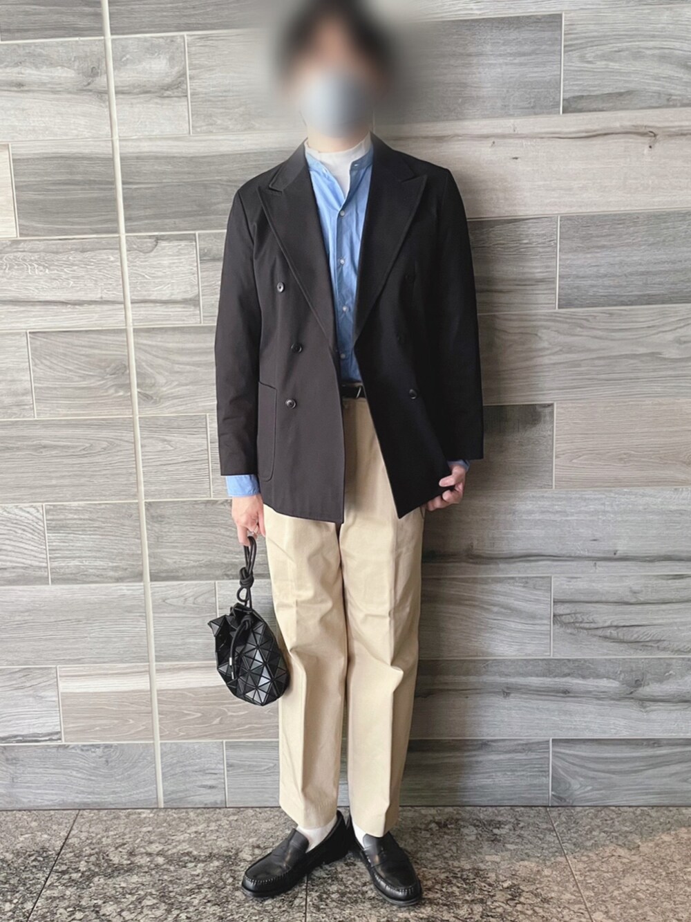 ブラック系のテーラードジャケット、ベージュ系のチノパンツ、ブルー系のシャツ/ブラウスを着用したメンズの春コーディネートの2枚目の写真