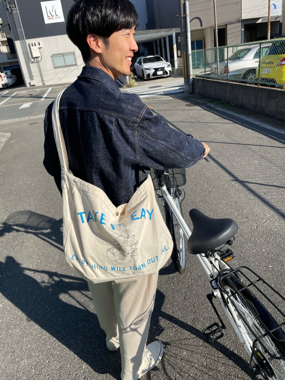 ブルー系のデニムジャケット、ホワイト系のショルダーバッグを着用したメンズの秋コーディネートの3枚目の写真