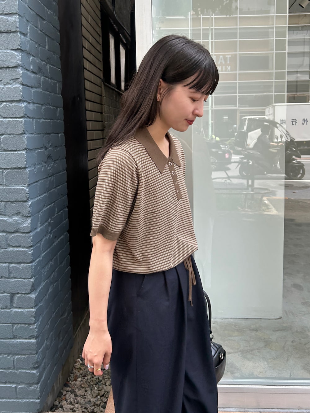 ブラウン系のポロシャツを着用したレディースの夏コーディネートの3枚目の写真