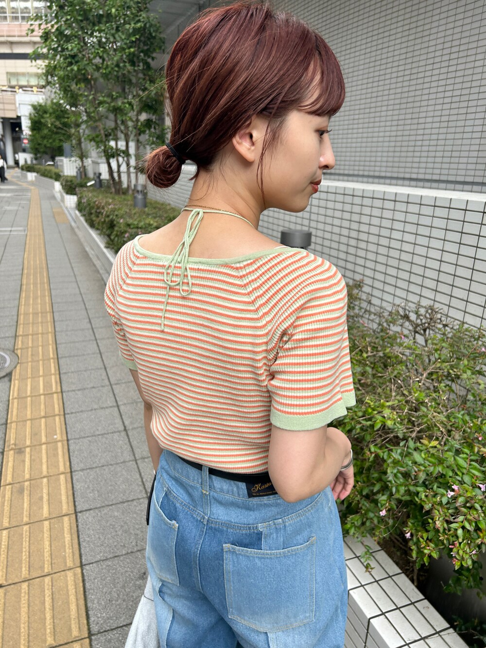 グリーン系のTシャツ/カットソー、ブルー系のデニムパンツ、シルバー系のハンドバッグを着用したレディースの夏コーディネートの3枚目の写真