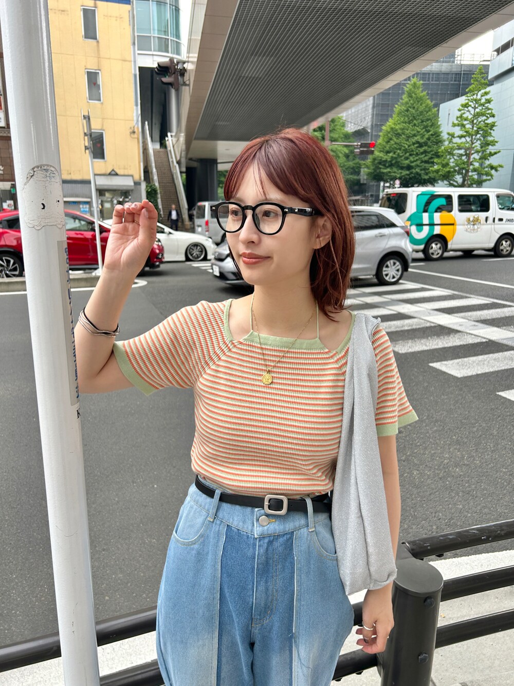グリーン系のTシャツ/カットソー、ブルー系のデニムパンツ、シルバー系のハンドバッグを着用したレディースの夏コーディネートの2枚目の写真