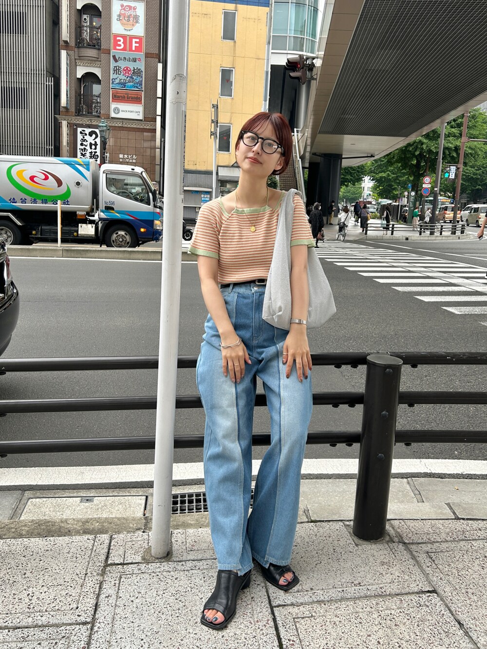 グリーン系のTシャツ/カットソー、ブルー系のデニムパンツ、シルバー系のハンドバッグを着用したレディースの夏コーディネートの4枚目の写真