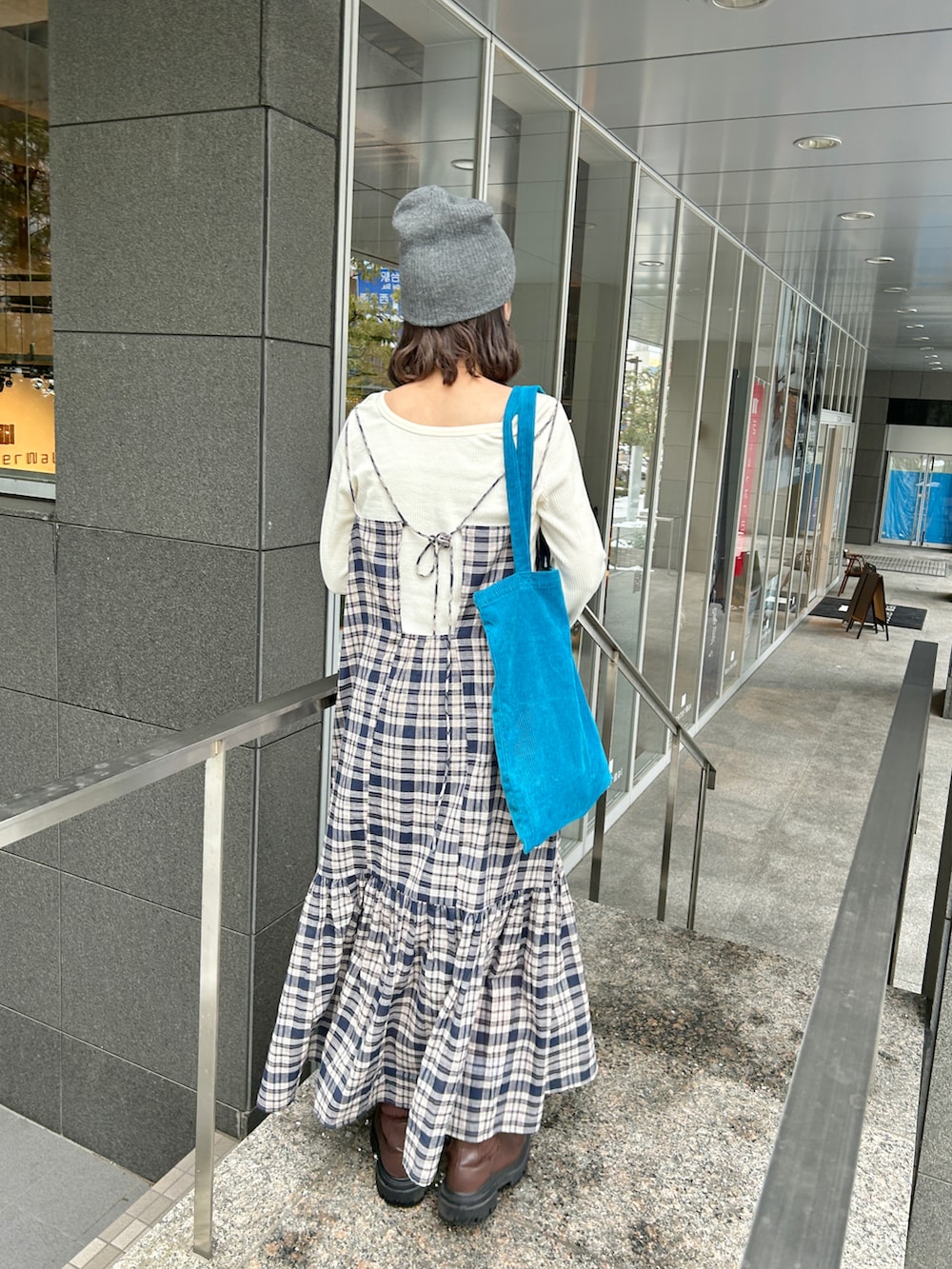 ホワイト系のTシャツ/カットソー、ブラウン系のブーツ、ブルー系のワンピースを着用したレディースの冬コーディネートの4枚目の写真