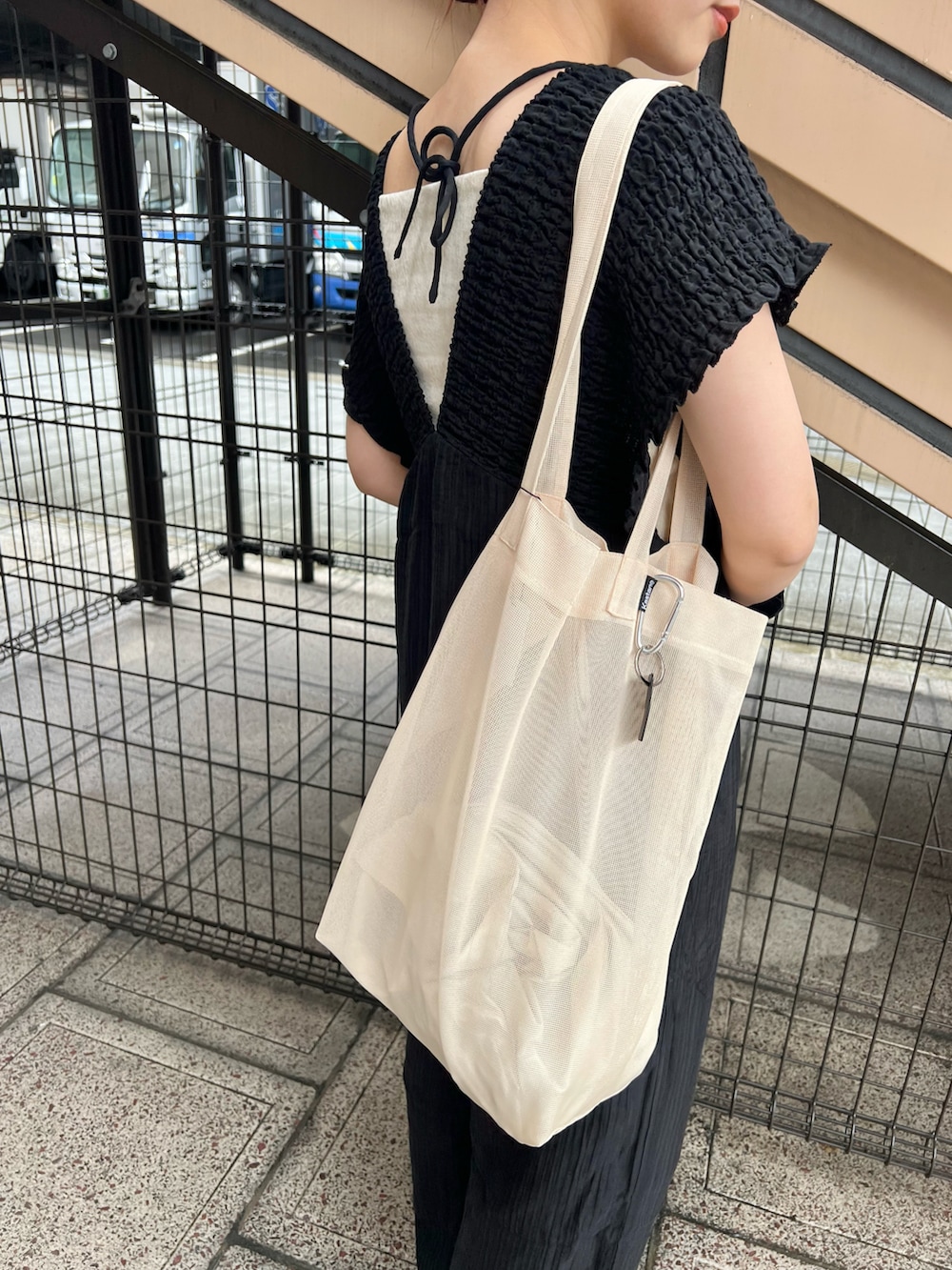 ブラック系のつなぎ/オールインワン、ホワイト系のキャミソール、ホワイト系のトートバッグを着用したレディースの夏コーディネートの4枚目の写真