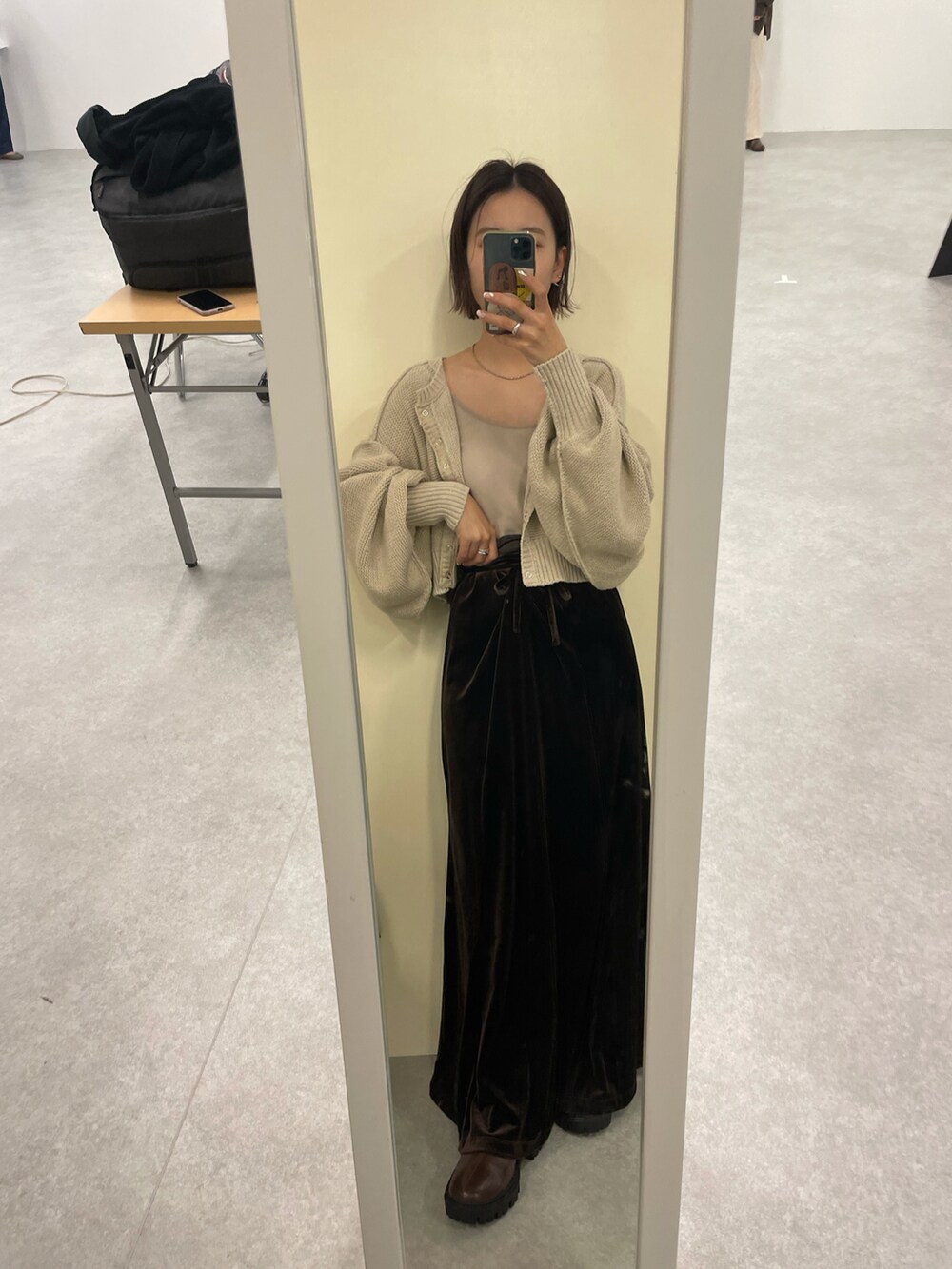 ブラウン系のワンピース、ホワイト系のカーディガン/ボレロ、ベージュ系のキャミソールを着用したレディースの冬コーディネートの2枚目の写真