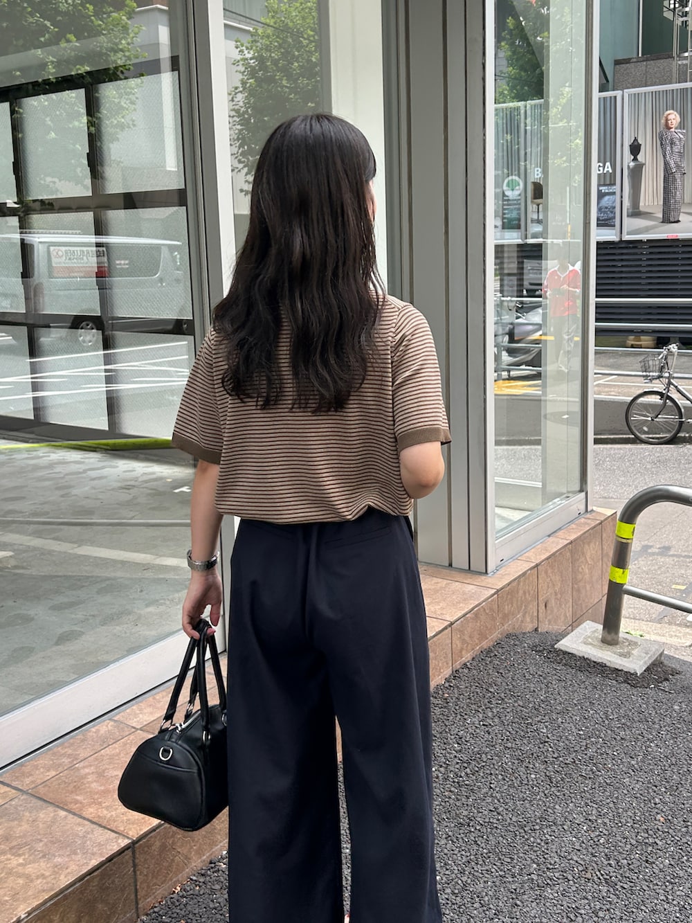 ブラウン系のポロシャツを着用したレディースの夏コーディネートの2枚目の写真