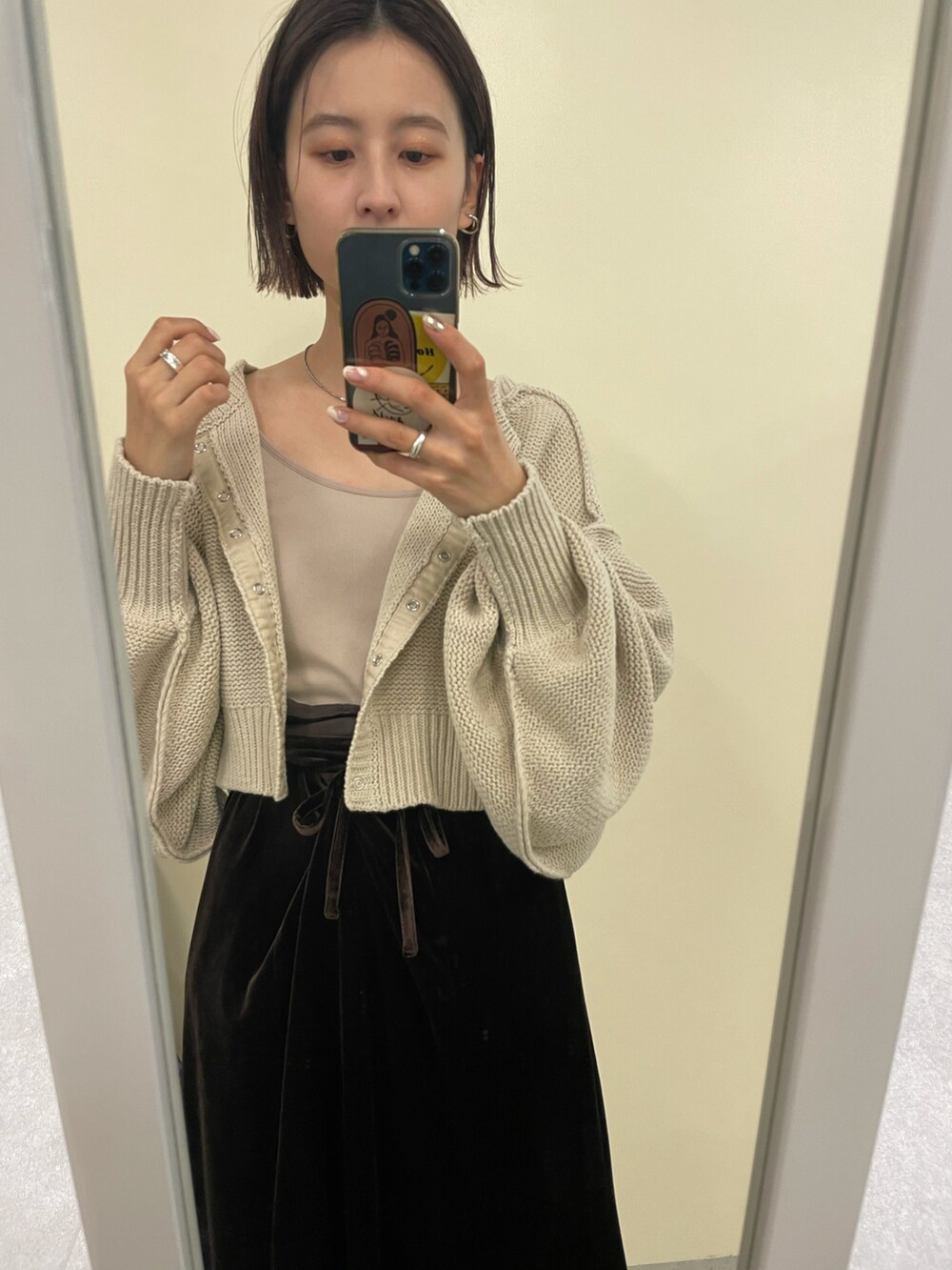 ブラウン系のワンピース、ホワイト系のカーディガン/ボレロ、ベージュ系のキャミソールを着用したレディースの冬コーディネートの3枚目の写真