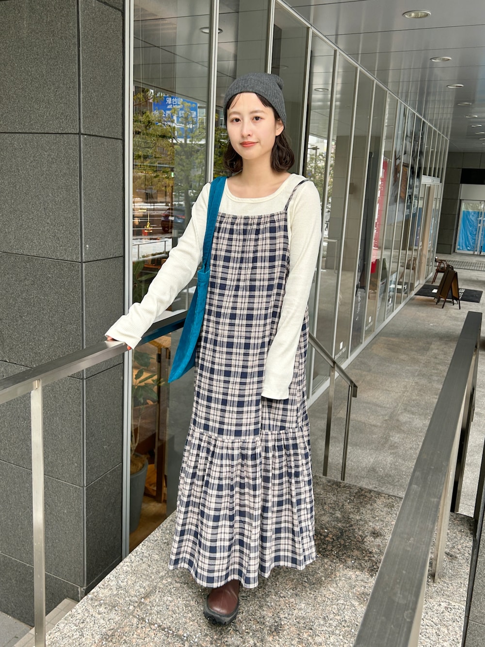 ホワイト系のTシャツ/カットソー、ブラウン系のブーツ、ブルー系のワンピースを着用したレディースの冬コーディネートの2枚目の写真