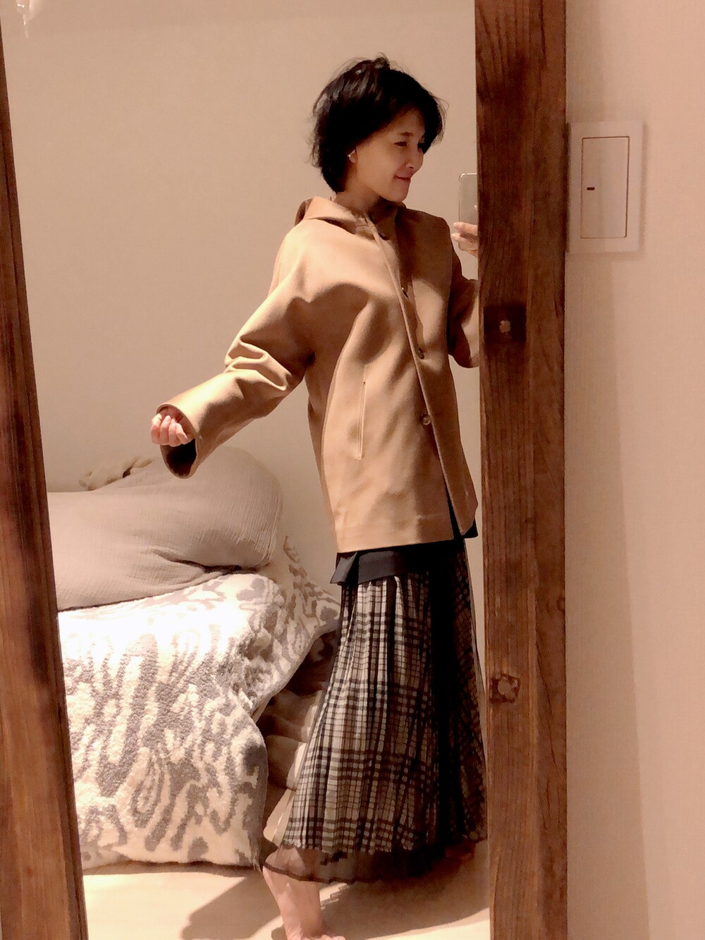 ベージュ系のトップス、ブラック系のスカートを着用したレディースの秋コーディネートの2枚目の写真