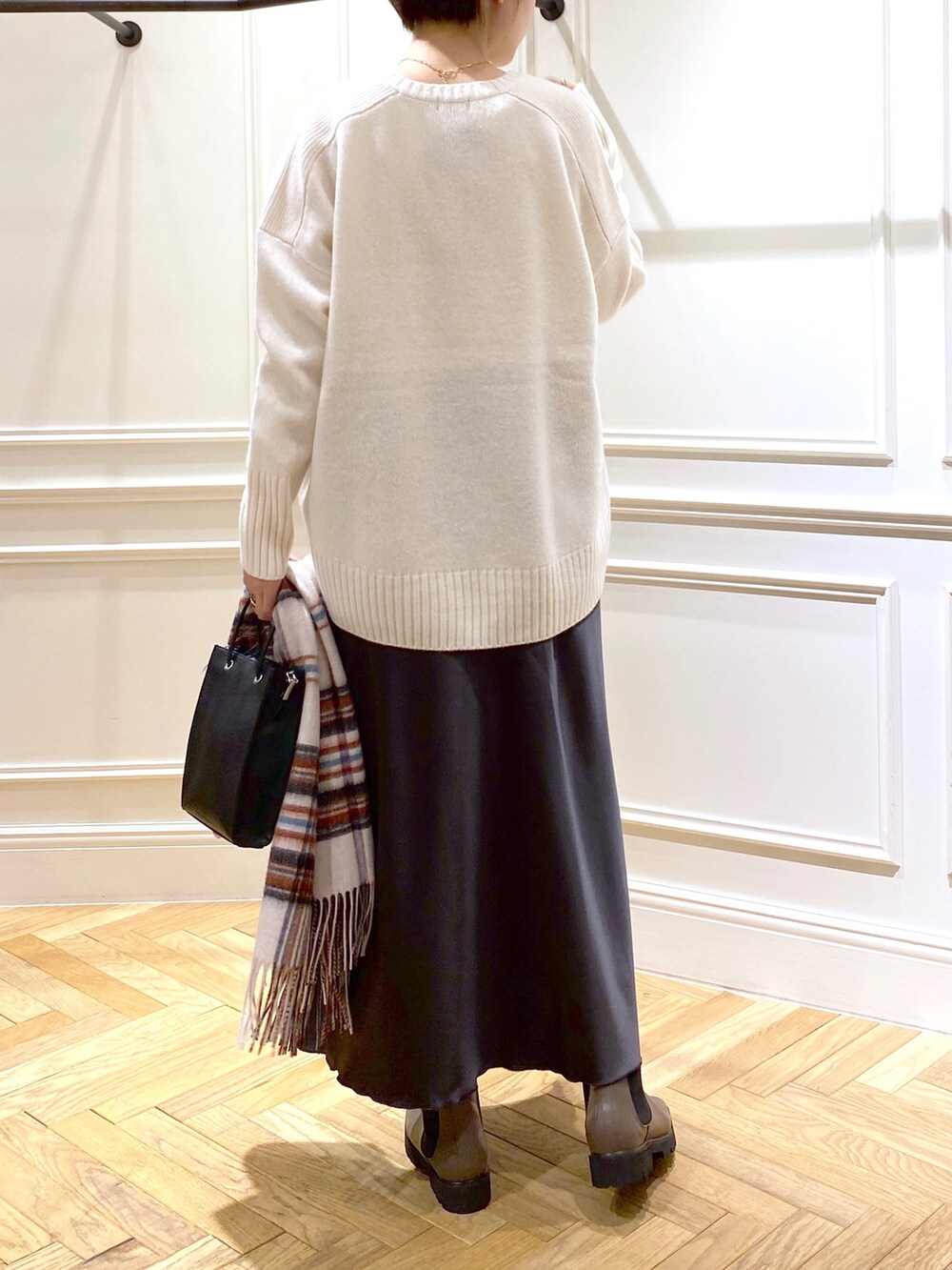 ホワイト系のニット/セーター、グレー系のスカート、ブラック系のショルダーバッグを着用したレディースの秋コーディネートの3枚目の写真