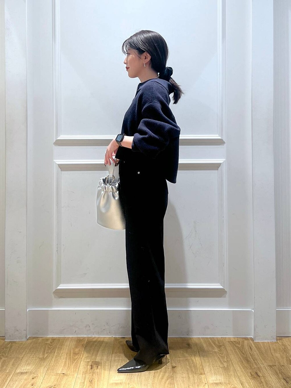 ブラック系のデニムパンツ、ブルー系のカーディガン/ボレロ、シルバー系のショルダーバッグを着用したレディースの秋コーディネートの2枚目の写真