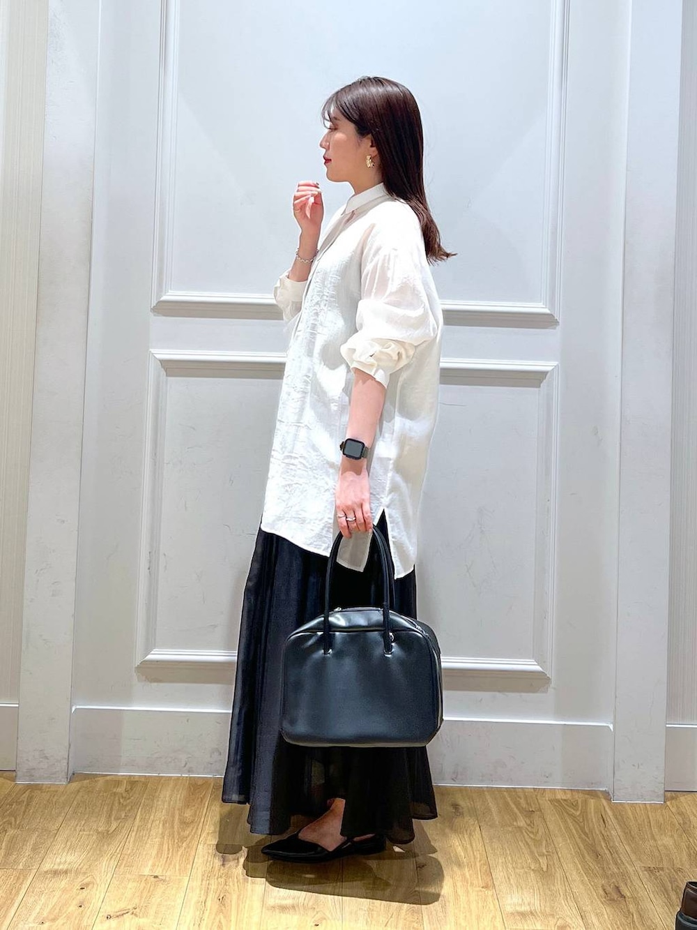 ブラック系のボストンバッグ、ブラック系のスカート、ブラック系のパンプスを着用したレディースの春コーディネートの2枚目の写真