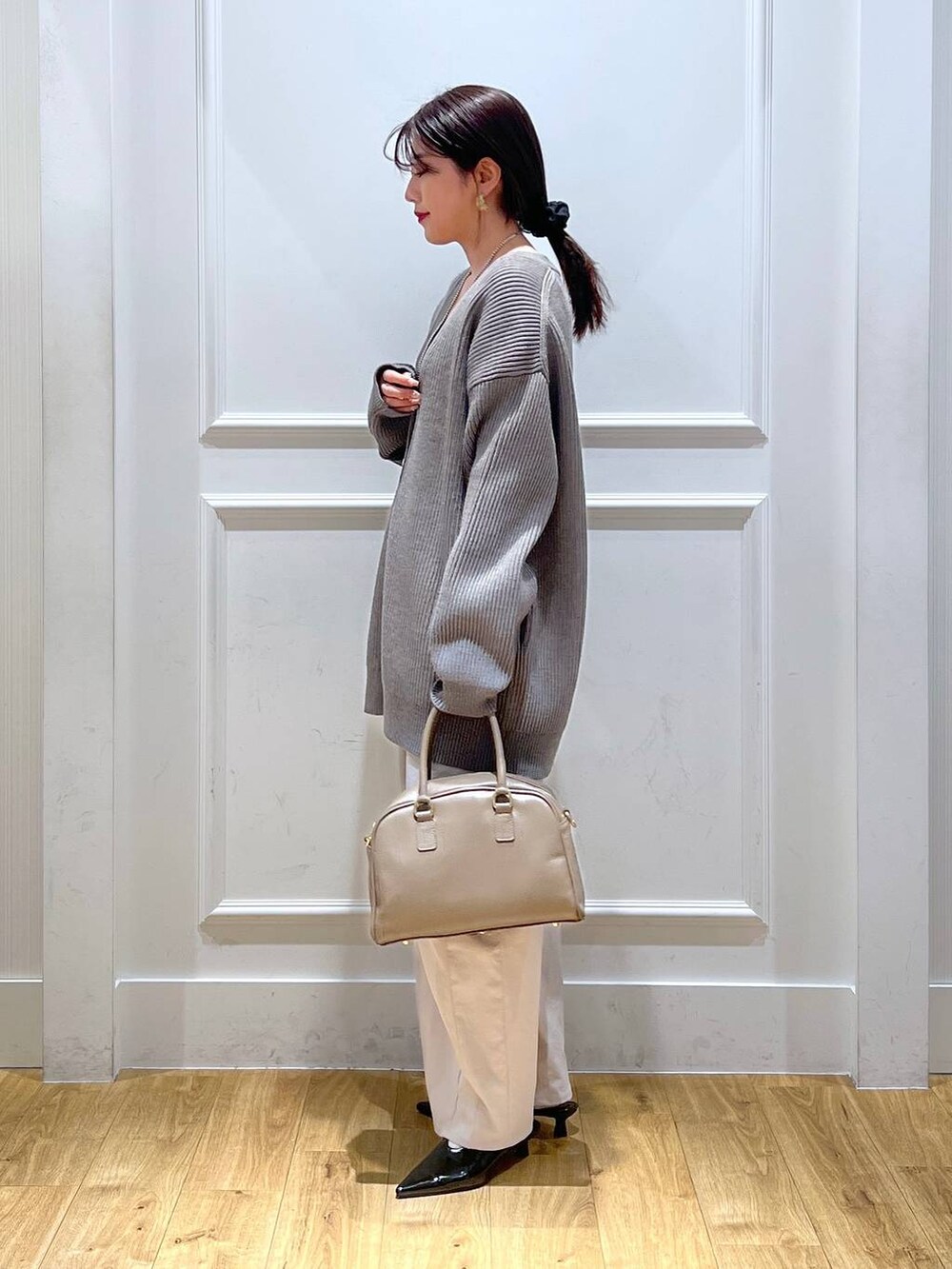 ブラック系のパンプス、グレー系のその他パンツ、イエロー系のカーディガン/ボレロを着用したレディースの冬コーディネートの2枚目の写真