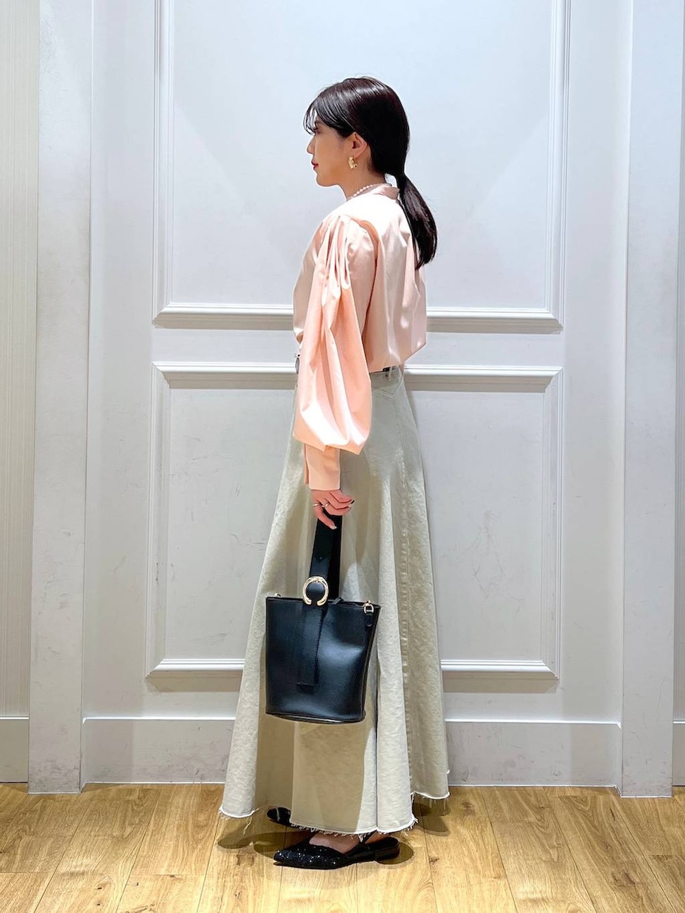 ベージュ系のデニムスカート、ブラック系のショルダーバッグ、ピンク系のシャツ/ブラウスを着用したレディースの冬コーディネートの2枚目の写真