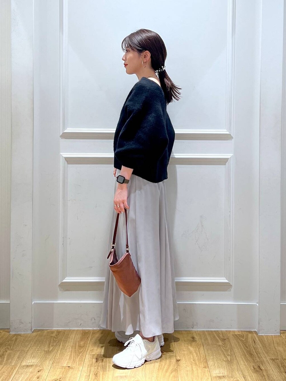 ホワイト系のスニーカー、ブラック系のカーディガン/ボレロ、ブラウン系のハンドバッグを着用したレディースの秋コーディネートの2枚目の写真