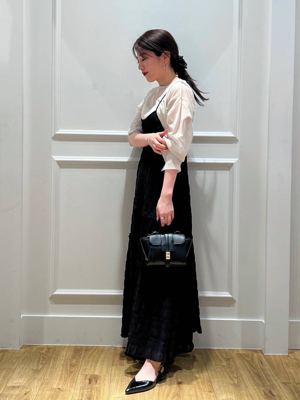 ブラック系のワンピース、ベージュ系のシャツ/ブラウス、ブラック系のパンプスを着用したレディースの春コーディネートの2枚目の写真