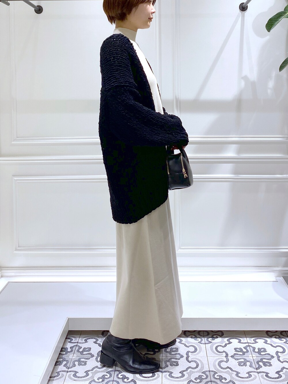 ベージュ系のワンピース、ブラック系のニット/セーター、ブラック系のブーツを着用したレディースの冬コーディネートの4枚目の写真