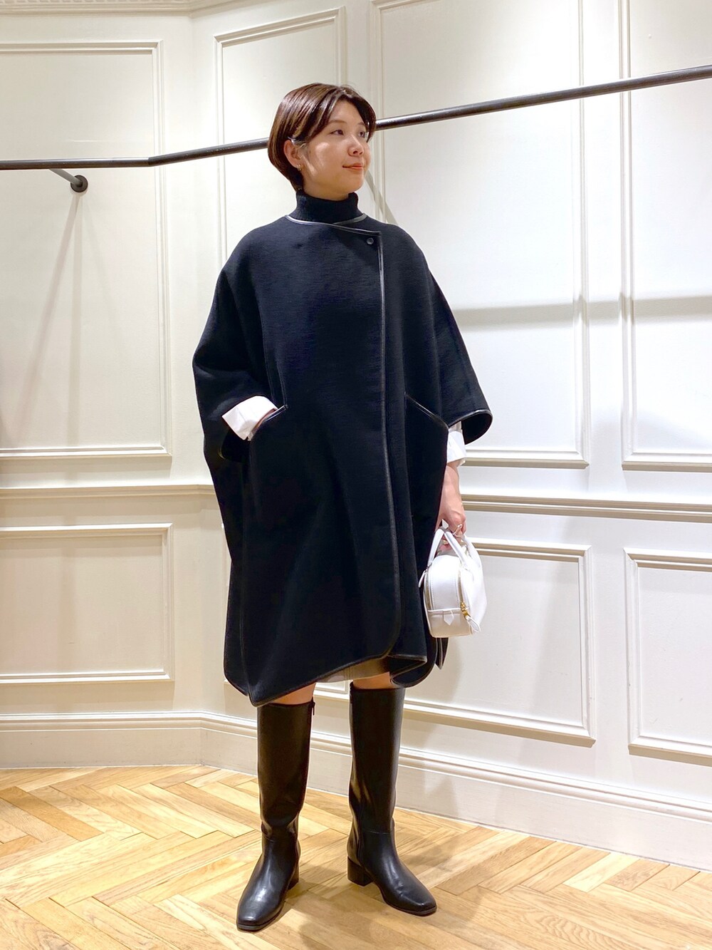 ブラック系のポンチョ、ブラック系のベスト、ホワイト系のシャツ/ブラウスを着用したレディースの秋コーディネートの3枚目の写真