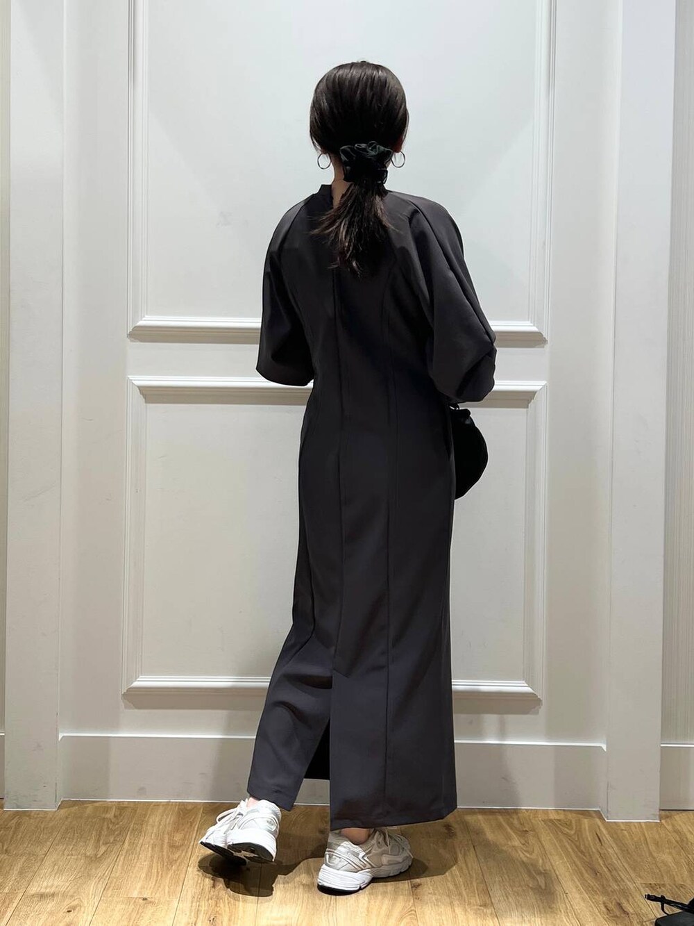 グレー系のワンピース、ブラック系のショルダーバッグ、シルバー系のネックレスを着用したレディースの春コーディネートの3枚目の写真