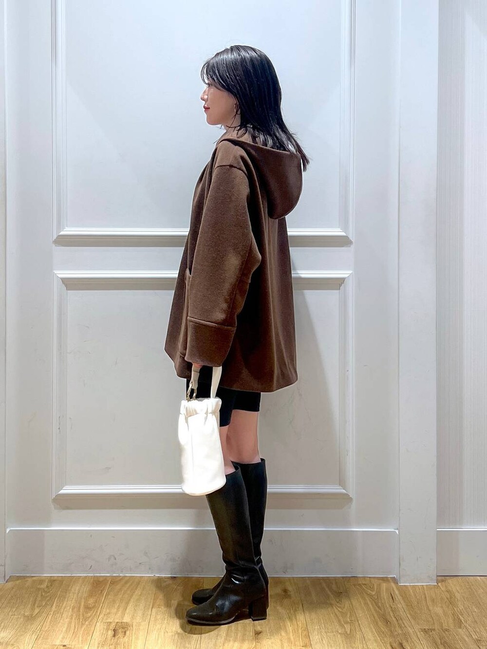 ホワイト系のショルダーバッグ、ブラウン系のその他アウター、ブラック系のレギンス/スパッツを着用したレディースの秋コーディネートの2枚目の写真