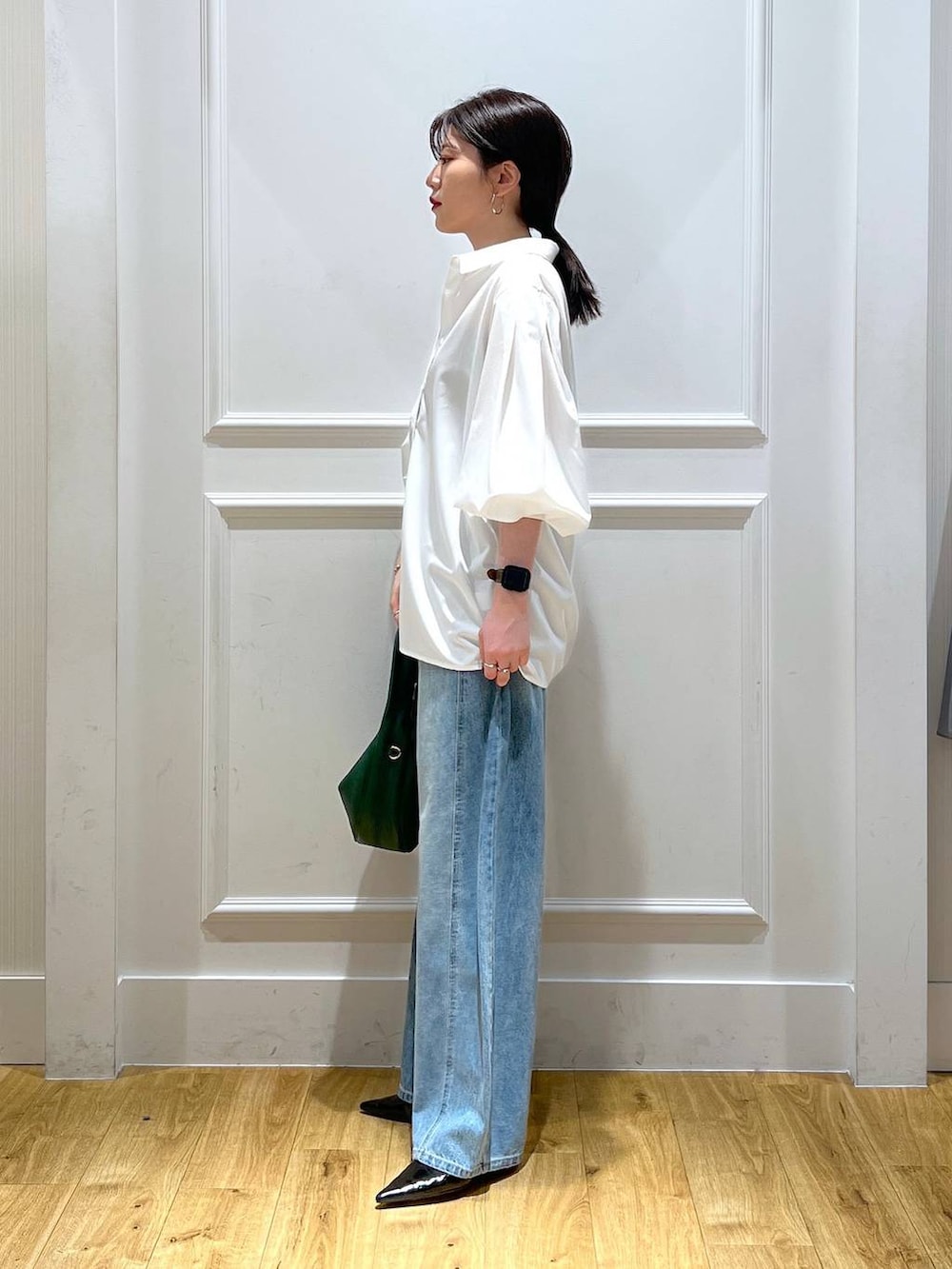 ホワイト系のシャツ/ブラウス、ブルー系のデニムパンツ、グリーン系のハンドバッグを着用したレディースの秋コーディネートの2枚目の写真