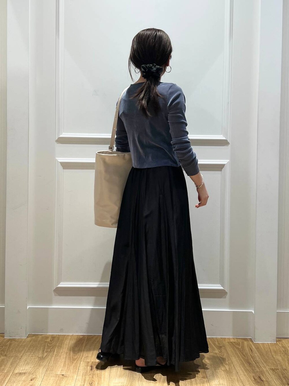 ホワイト系のトートバッグ、ブラック系のスカート、ブラック系のパンプスを着用したレディースの春コーディネートの3枚目の写真