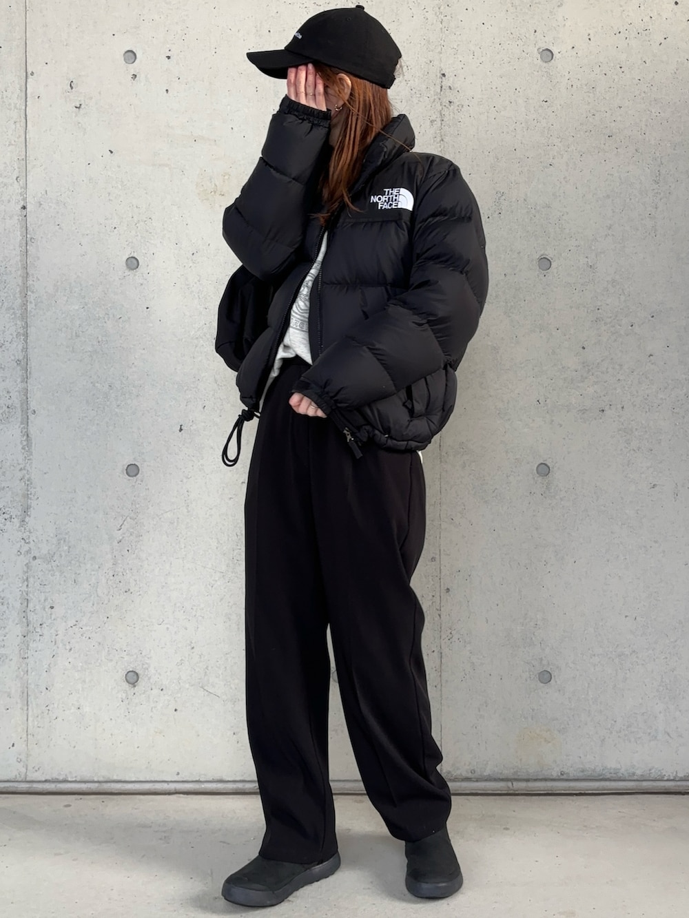 ブラック系のダウンジャケット/コート、ブラック系のブーツ、ブラック系のショルダーバッグを着用したレディースの冬コーディネートの3枚目の写真