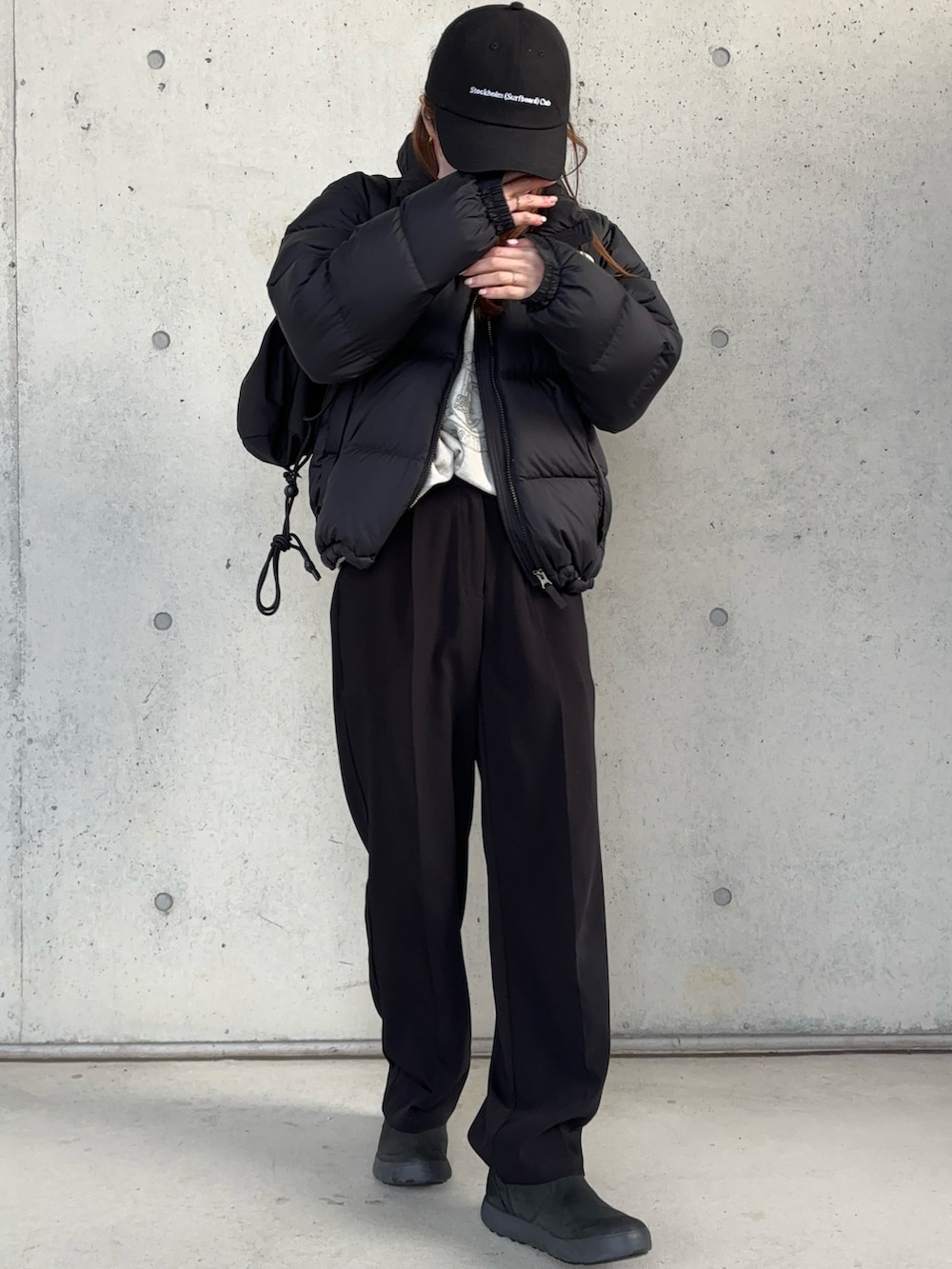 ブラック系のダウンジャケット/コート、ブラック系のブーツ、ブラック系のショルダーバッグを着用したレディースの冬コーディネートの2枚目の写真