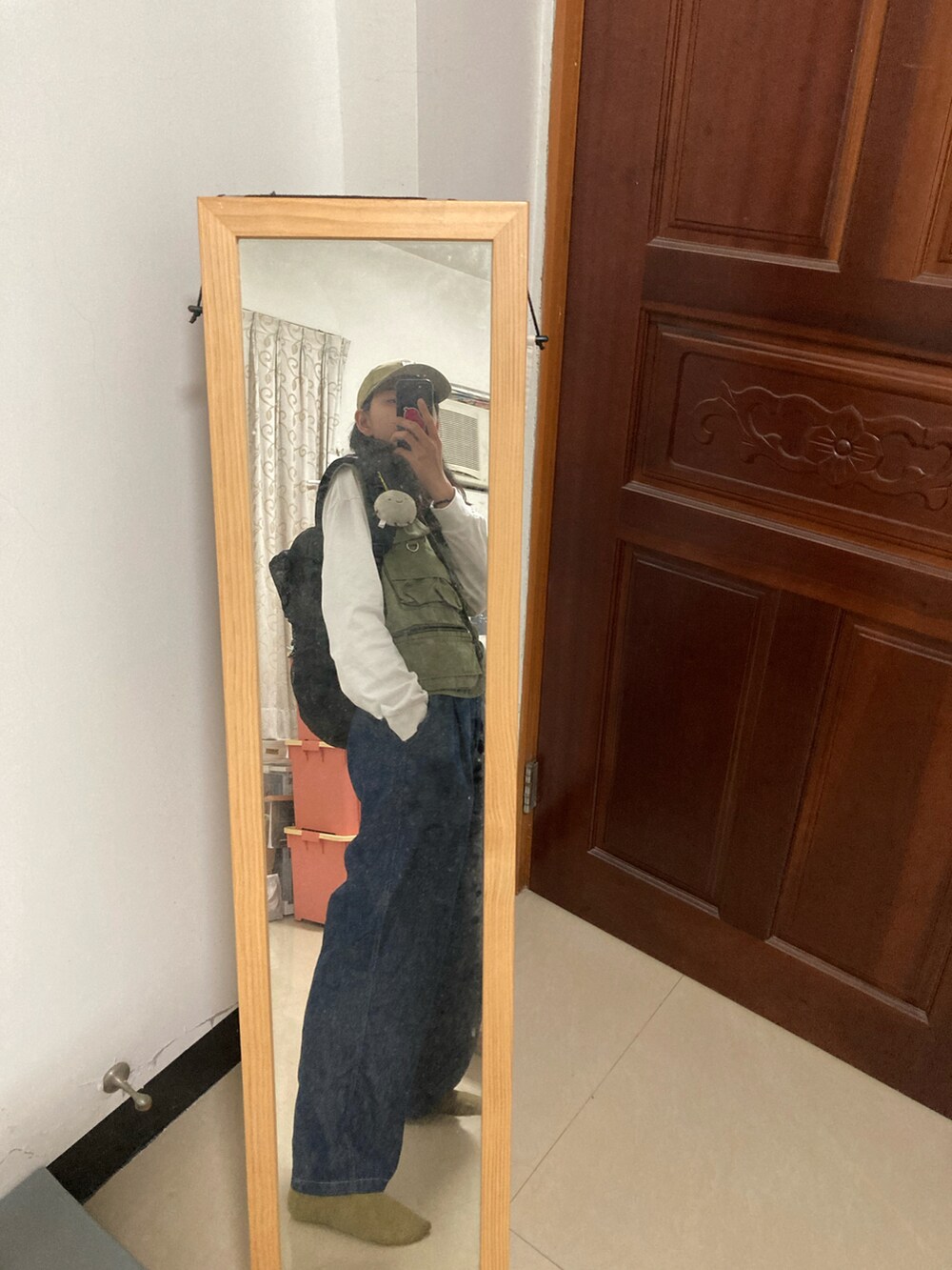 グリーン系のタンクトップ、ブルー系のデニムパンツ、グリーン系のキャップを着用したレディースの春コーディネートの3枚目の写真