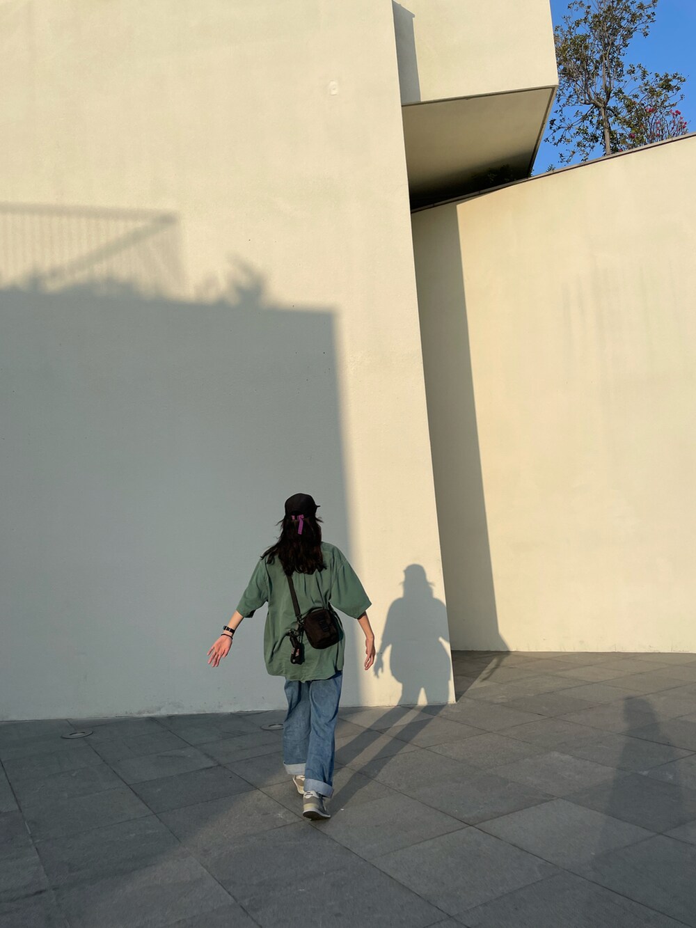 グリーン系のシャツ/ブラウス、ブルー系のデニムパンツ、グレー系のスニーカーを着用したレディースの秋コーディネートの3枚目の写真