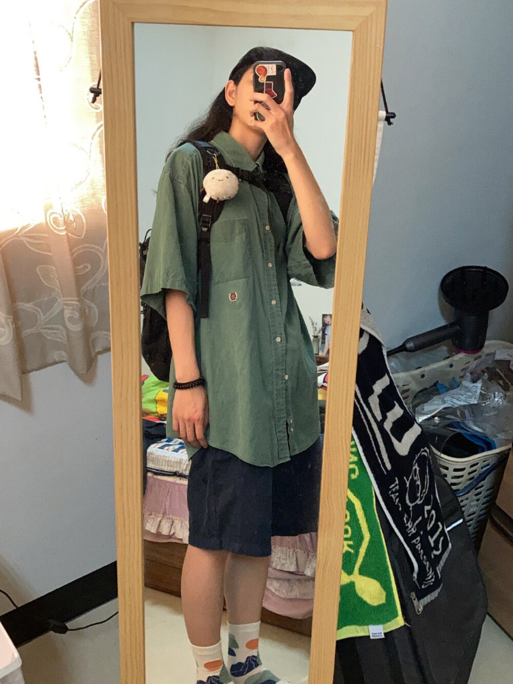 グリーン系のシャツ/ブラウス、ブラック系のハットを着用したレディースの夏コーディネートの2枚目の写真