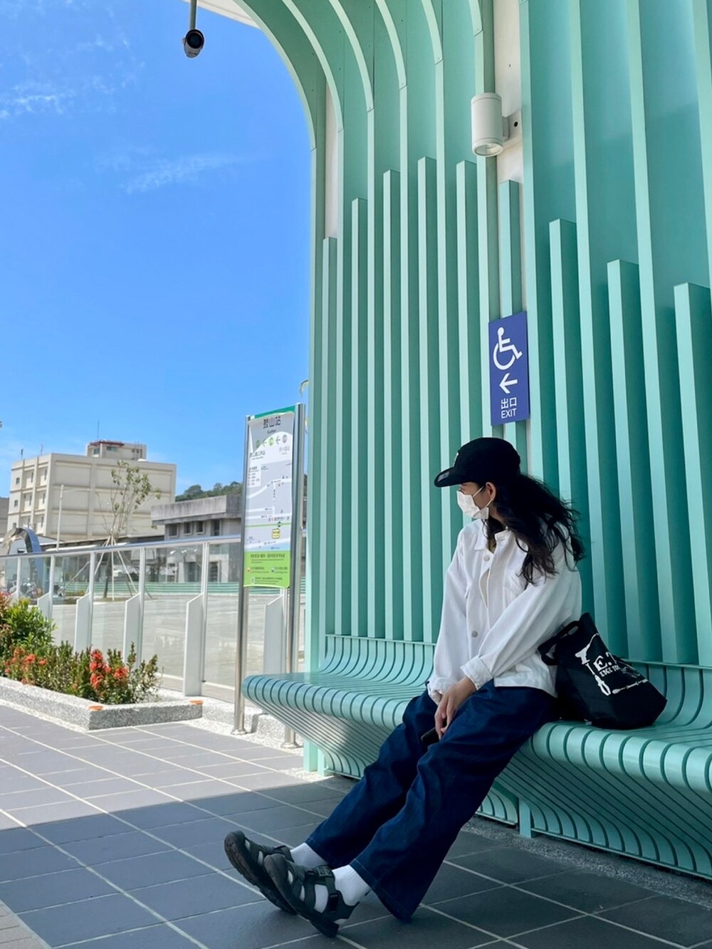 ブルー系のデニムパンツ、ホワイト系のデニムジャケット、グレー系のサンダルを着用したレディースの春コーディネートの2枚目の写真