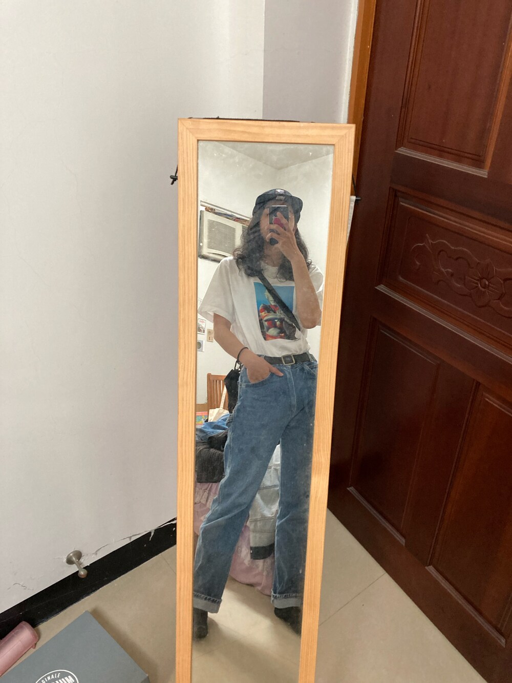 ブルー系のデニムパンツ、ホワイト系のTシャツ/カットソー、ブラック系のその他を着用したレディースの春コーディネートの2枚目の写真