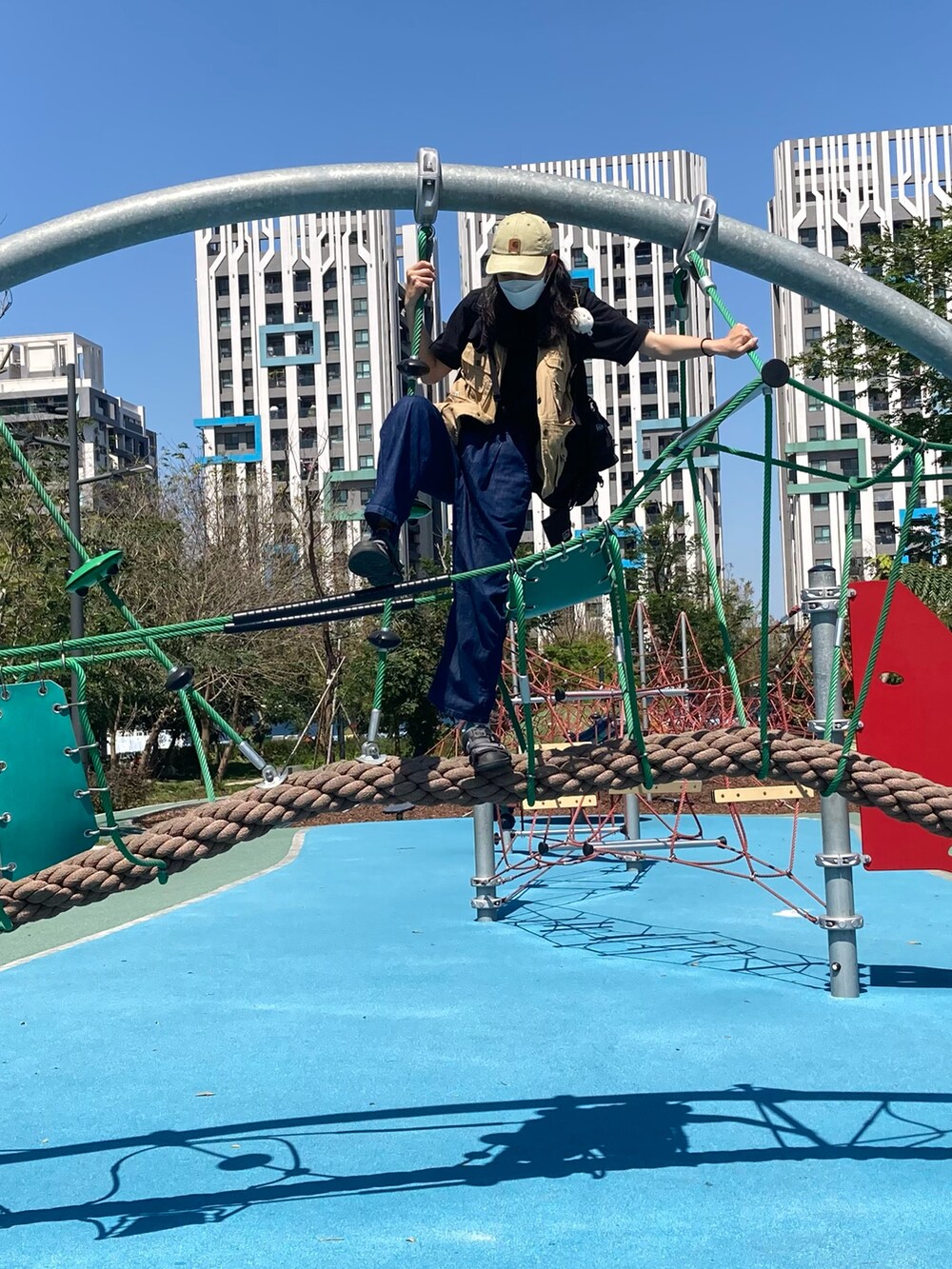 ブラック系のTシャツ/カットソー、グレー系のサンダル、ブルー系のデニムパンツを着用したレディースの春コーディネートの2枚目の写真