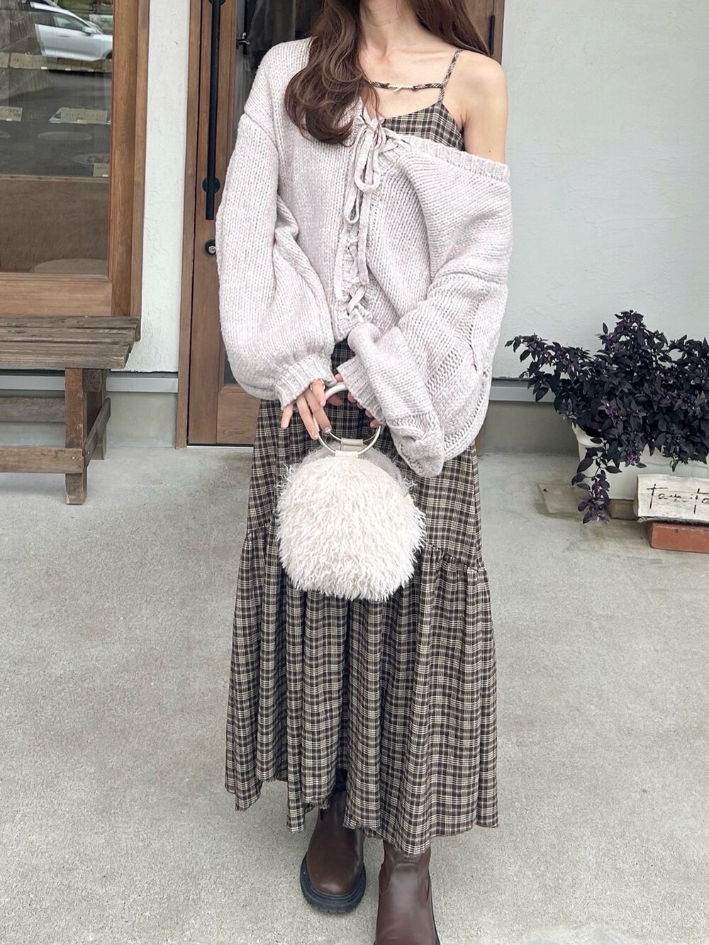 ホワイト系のショルダーバッグ、パープル系のニット/セーター、ブラウン系のワンピースを着用したレディースの秋コーディネートの2枚目の写真