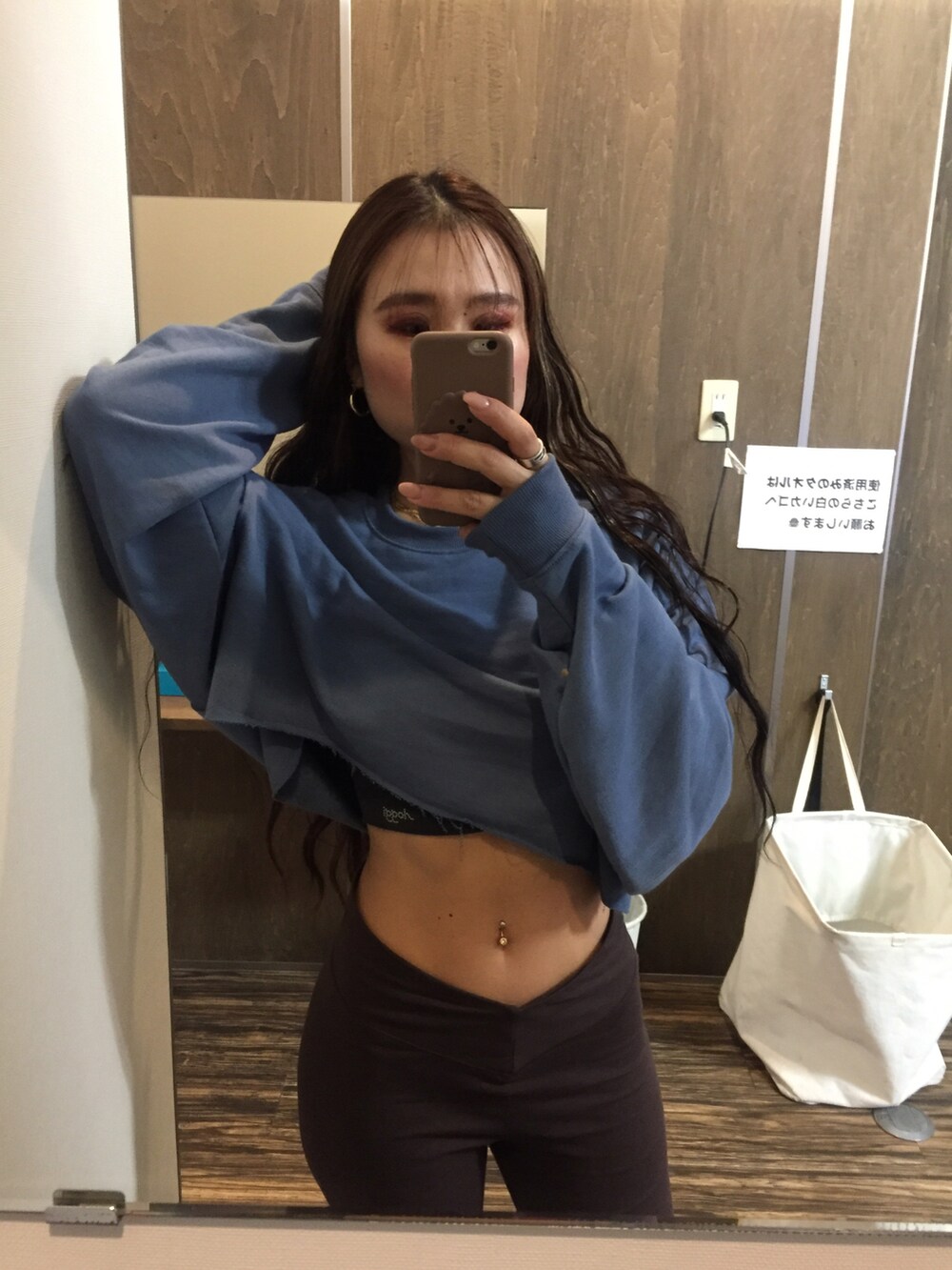 オレンジ系のスウェット、ブラウン系のレギンス/スパッツを着用したレディースの冬コーディネートの2枚目の写真