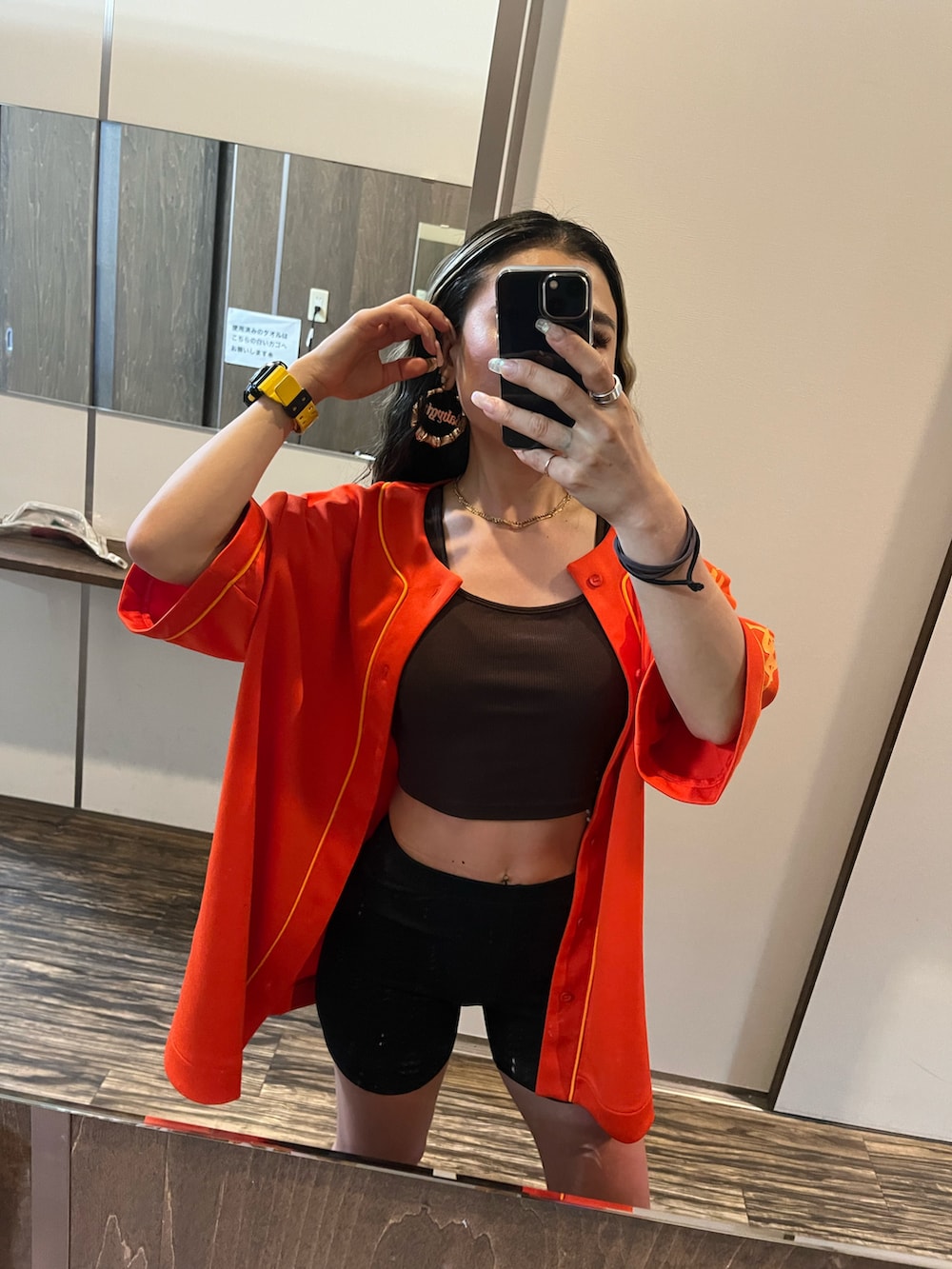 オレンジ系のシャツ/ブラウスを着用したレディースの夏コーディネートの2枚目の写真