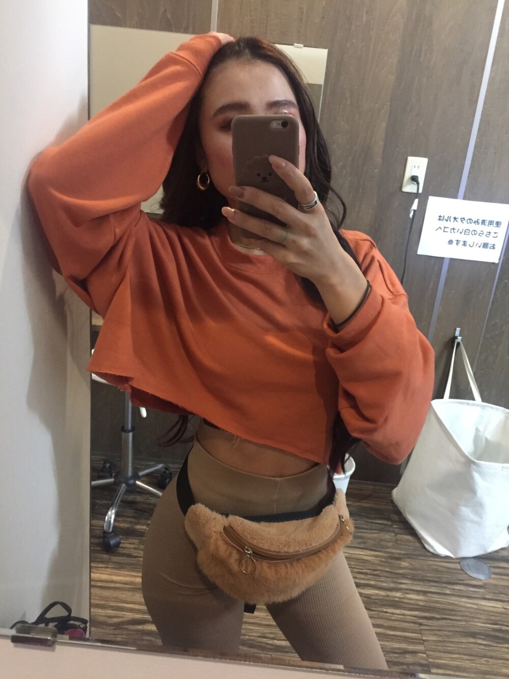 オレンジ系のスウェット、ベージュ系のレギンス/スパッツを着用したレディースの秋コーディネートの2枚目の写真