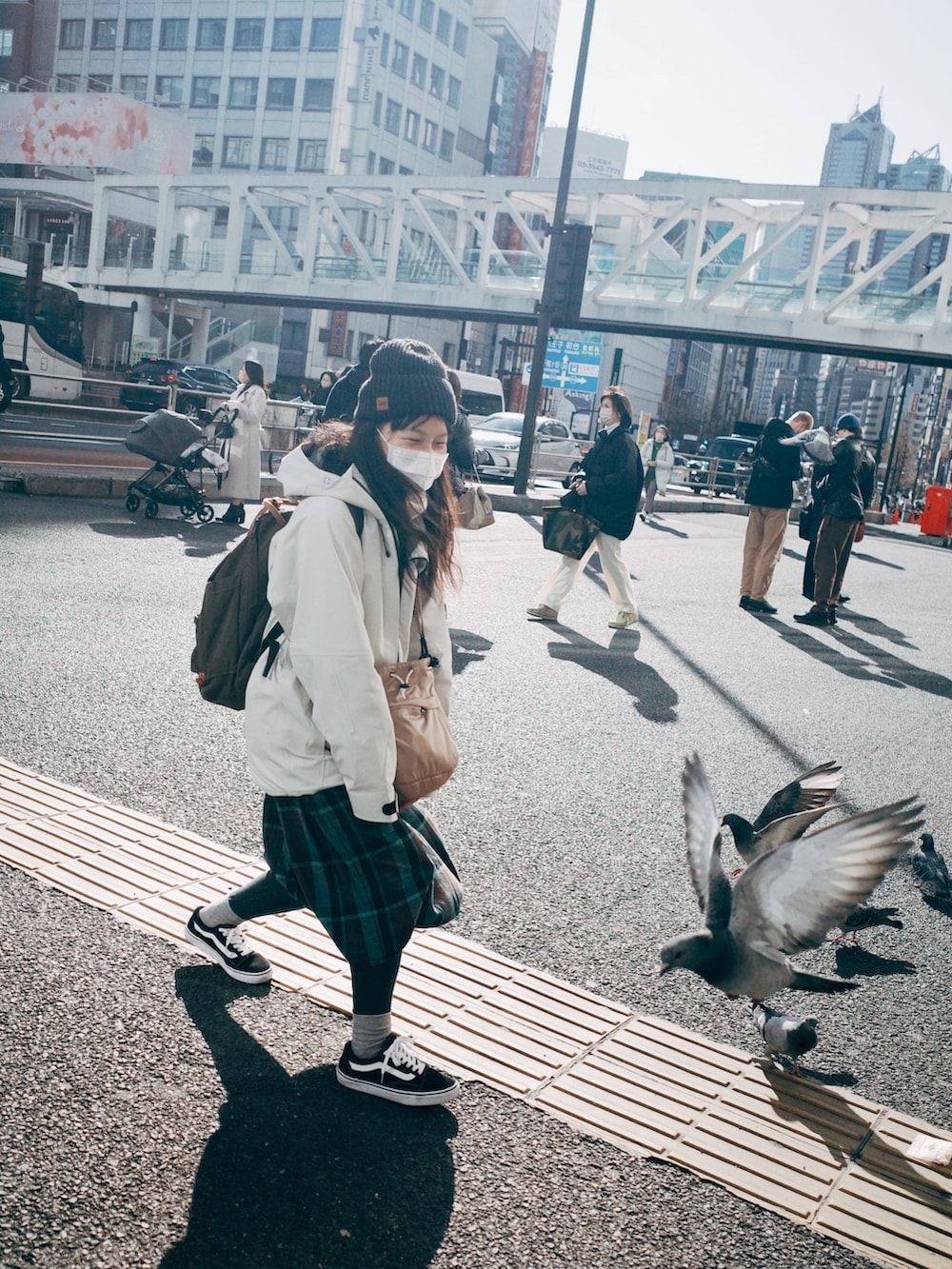 ホワイト系のマウンテンパーカー、グリーン系のスカート、ベージュ系のドラムバッグを着用したレディースの春コーディネートの2枚目の写真