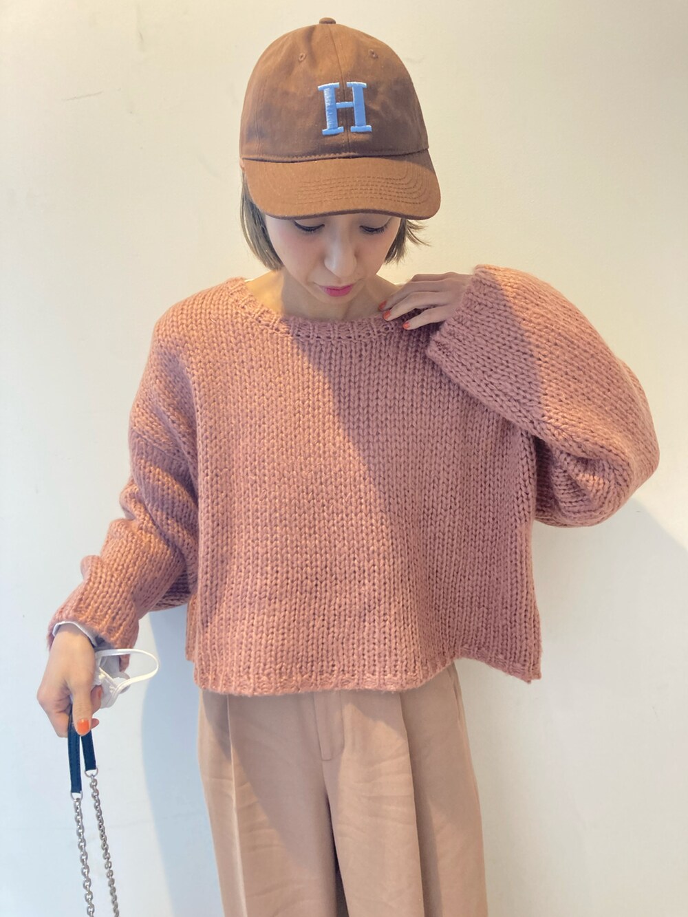 ベージュ系のパンツ、ピンク系のニット/セーターを着用したレディースの冬コーディネートの2枚目の写真