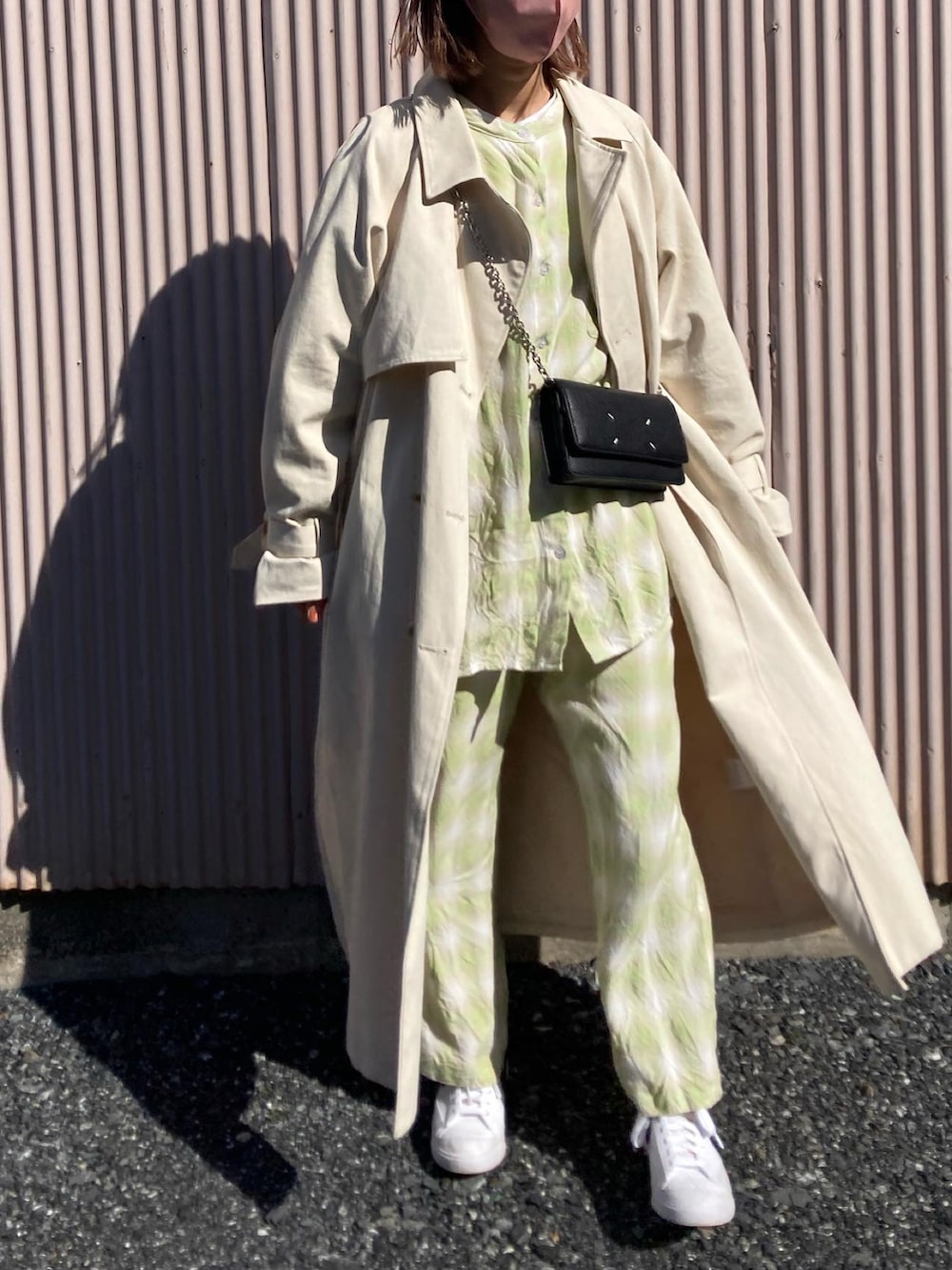 ホワイト系のスニーカー、ホワイト系のトレンチコートを着用したレディースの冬コーディネートの2枚目の写真