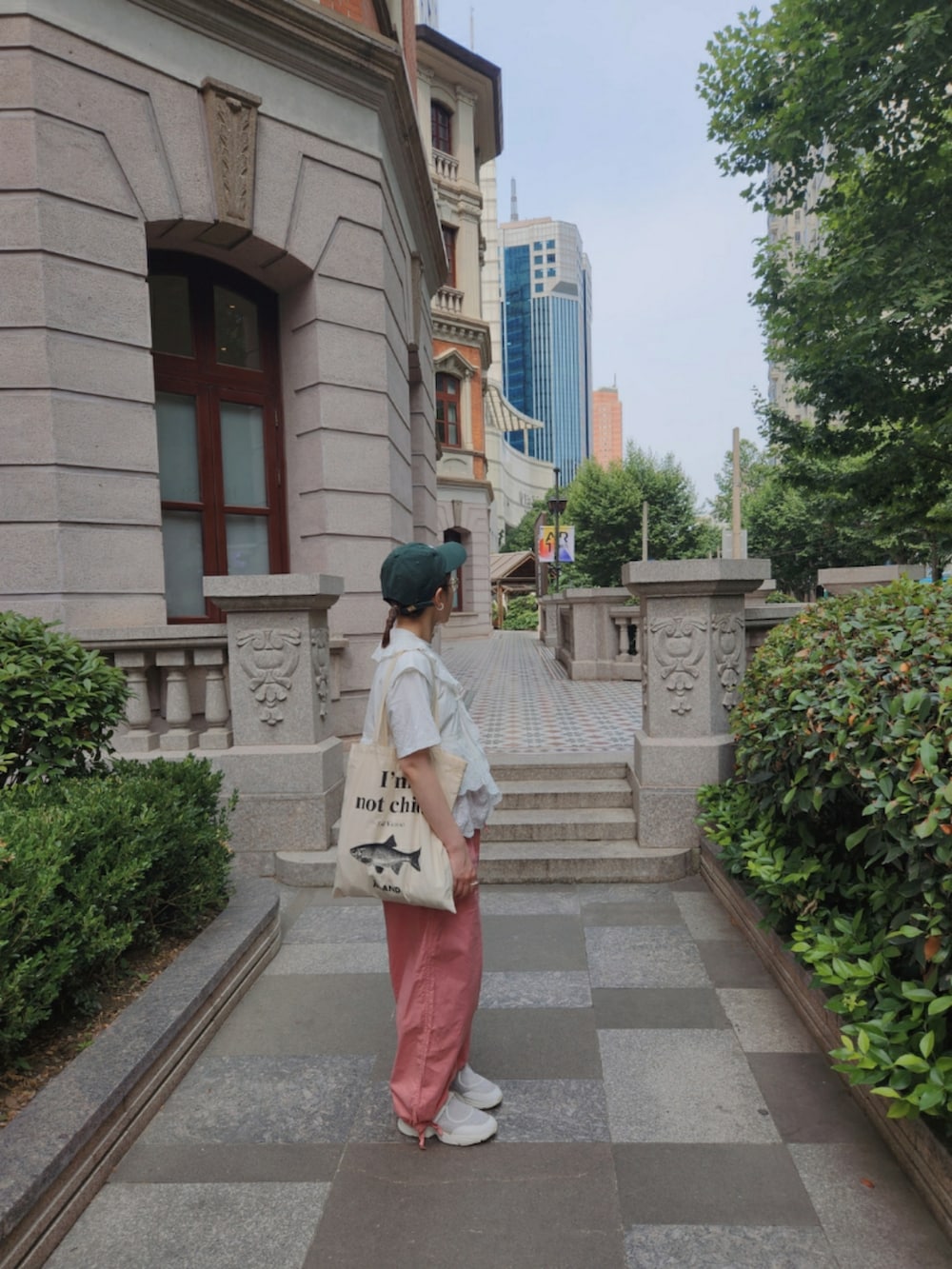 ホワイト系のTシャツ/カットソー、ピンク系のパンツ、ホワイト系のスニーカーを着用したレディースの夏コーディネートの2枚目の写真