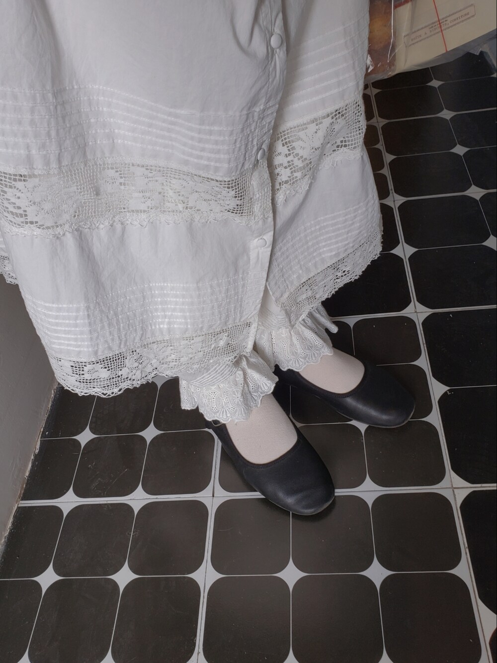 ブラウン系のトップス、ホワイト系のワンピース、ホワイト系のその他パンツを着用したレディースの春コーディネートの2枚目の写真