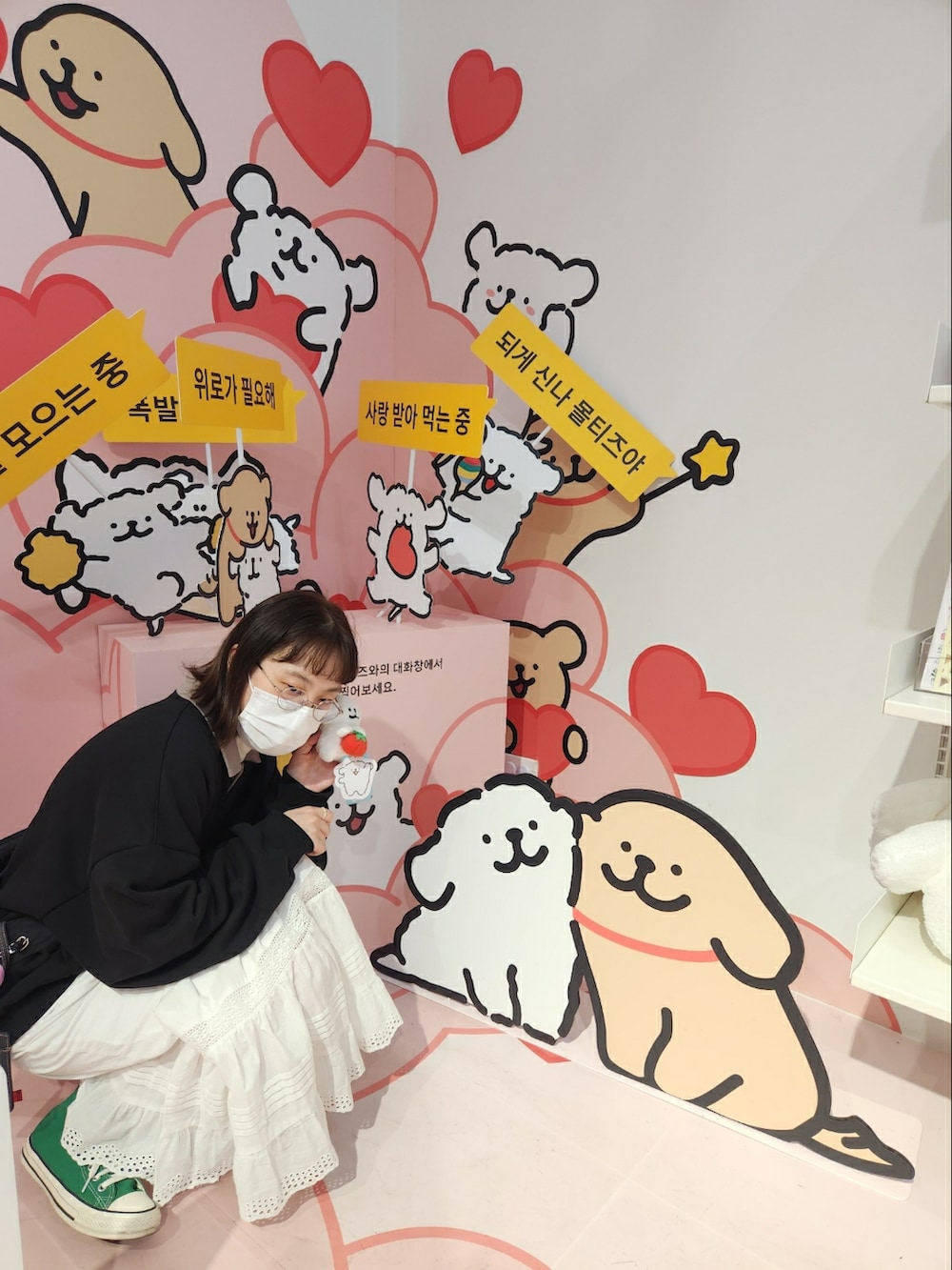 ブラック系のトップス、ホワイト系のスカート、グリーン系のスニーカーを着用したレディースの春コーディネートの2枚目の写真